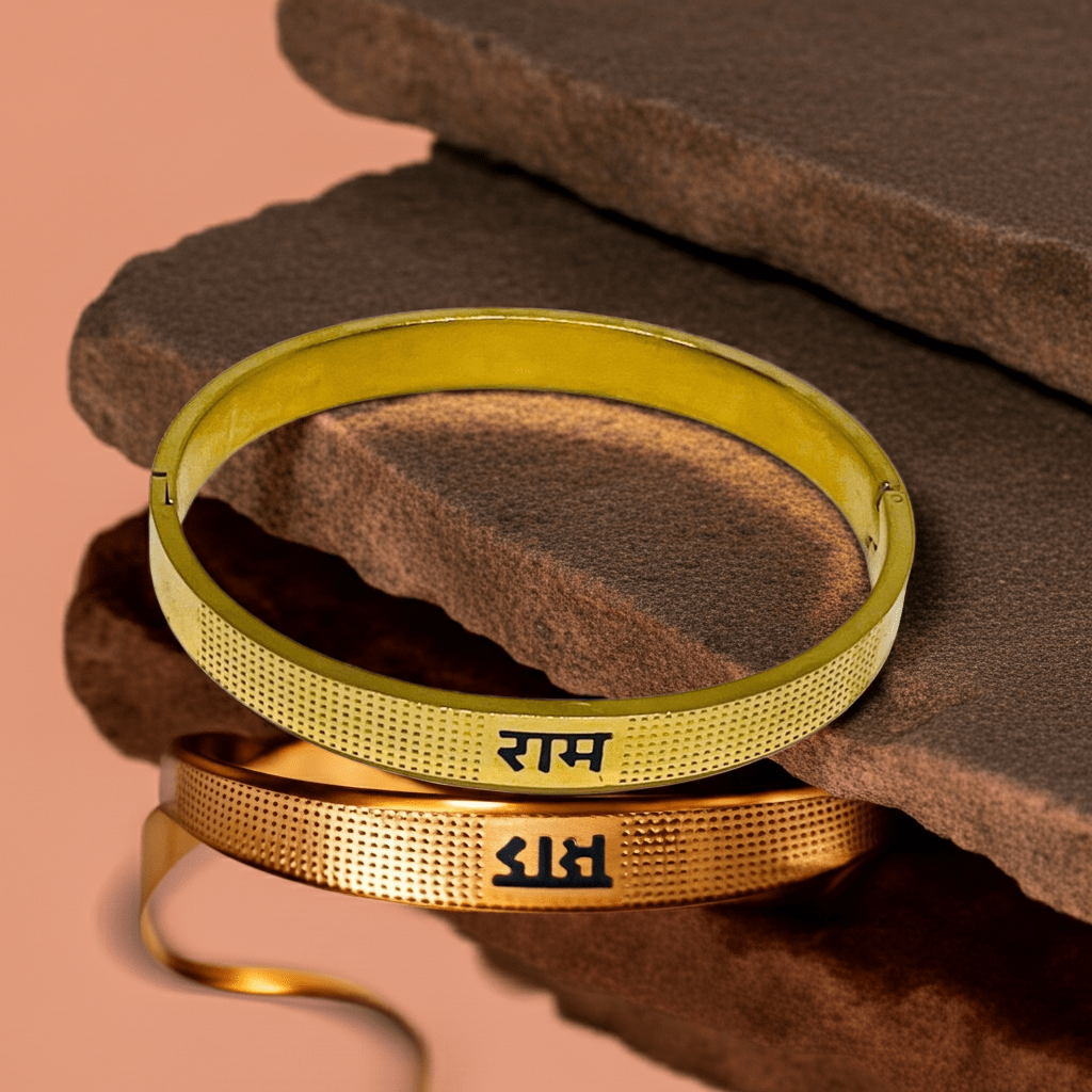 Two gold bangles with engraved Ram on a brown stone surface