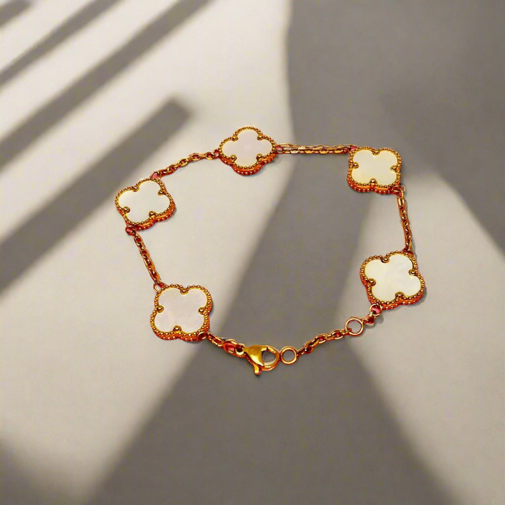 gold clover bracelet waterproof anti-tarnish with white clover-shaped links on a white background