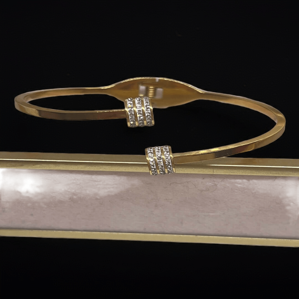 Gold bracelet with diamond accents on a reflective surface