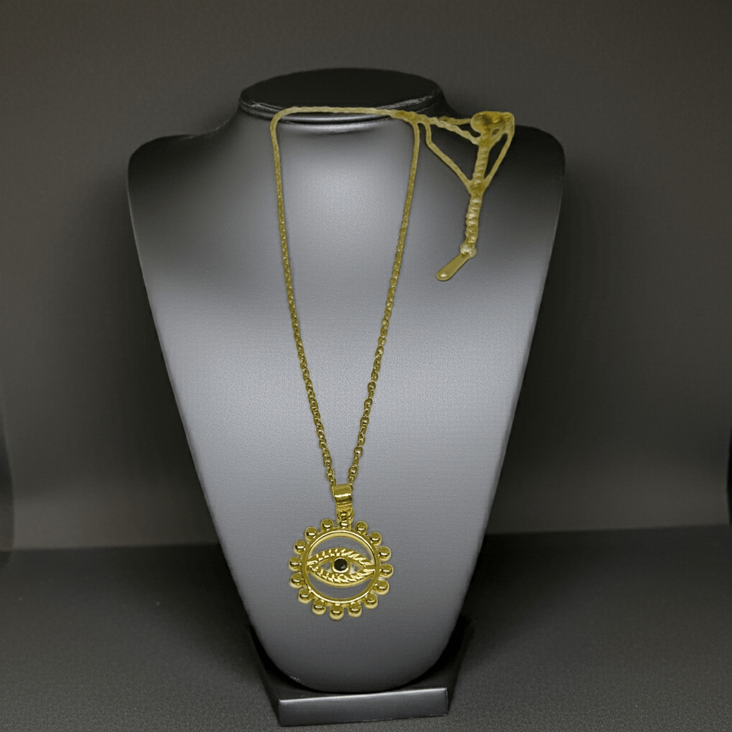 Gold necklace with a pendant on a gray mannequin bust against a dark background