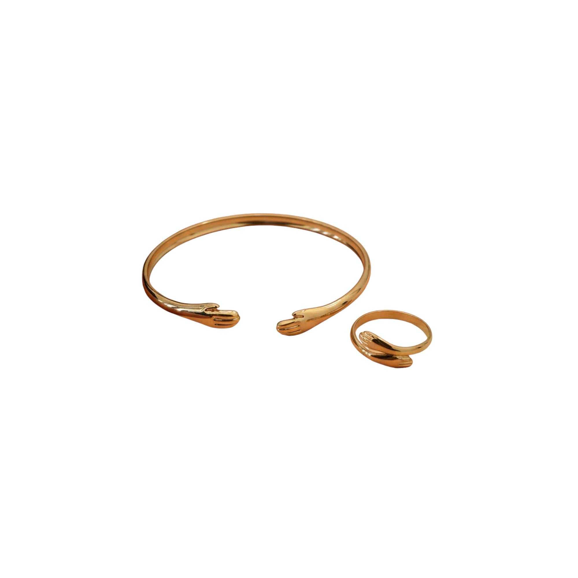 Gold bracelet and ring on a white background