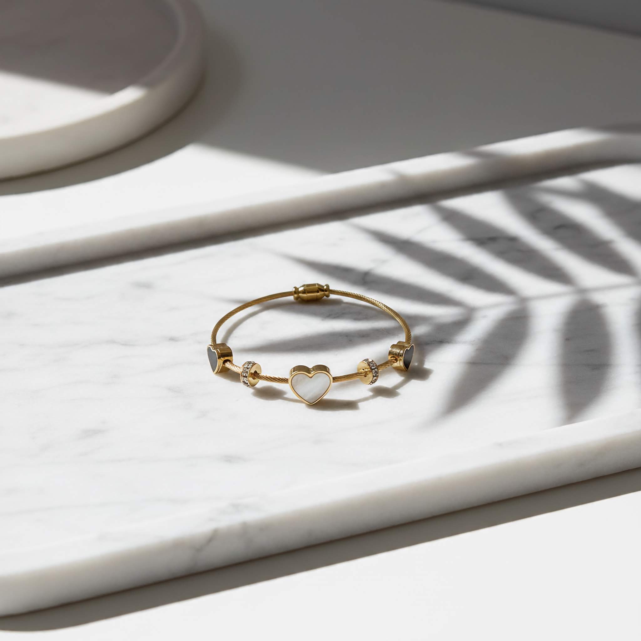 18k Gold plated bracelet with a heart charm on a marble surface