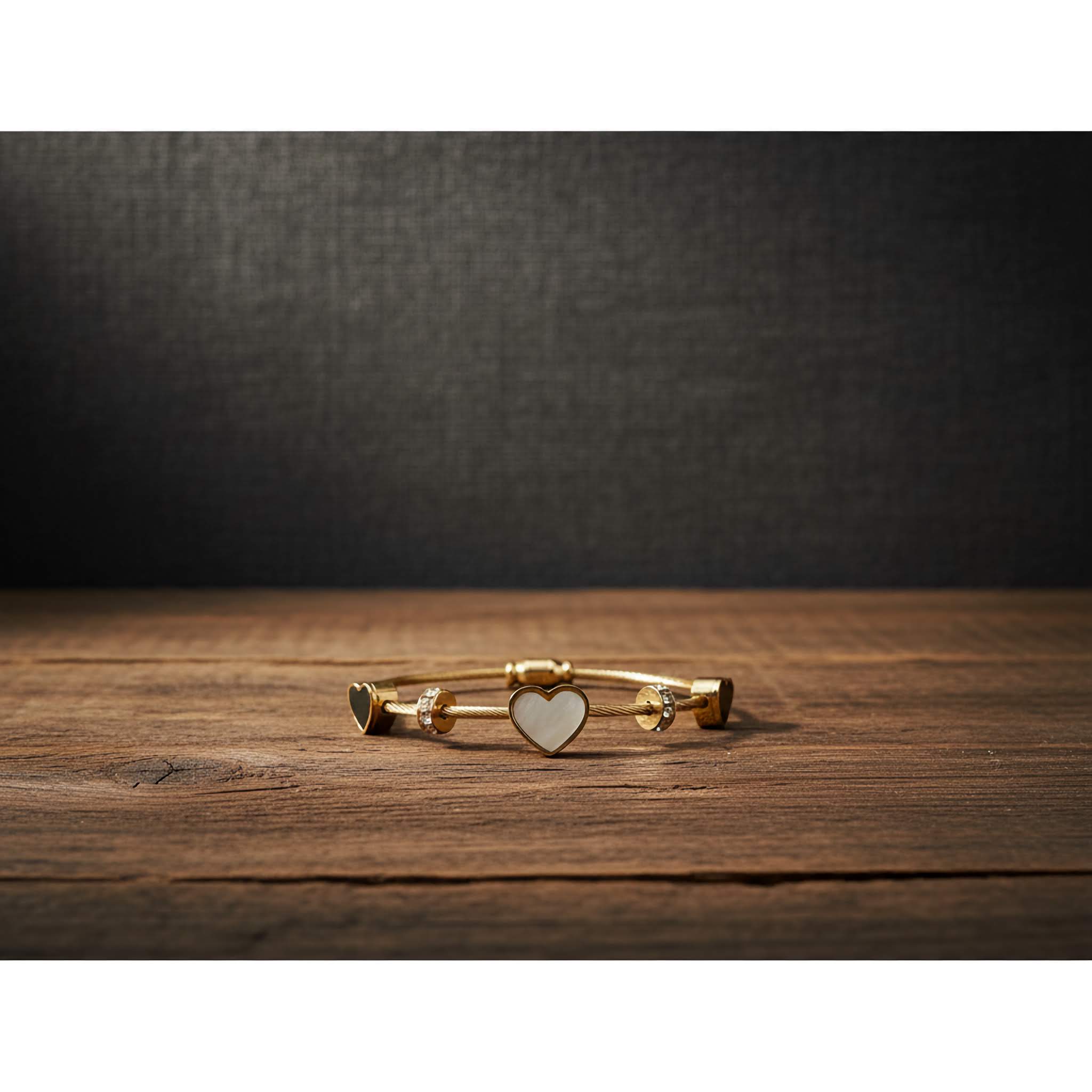 18k Gold plated bracelet with a heart charm with black and white colours on a wooden surface