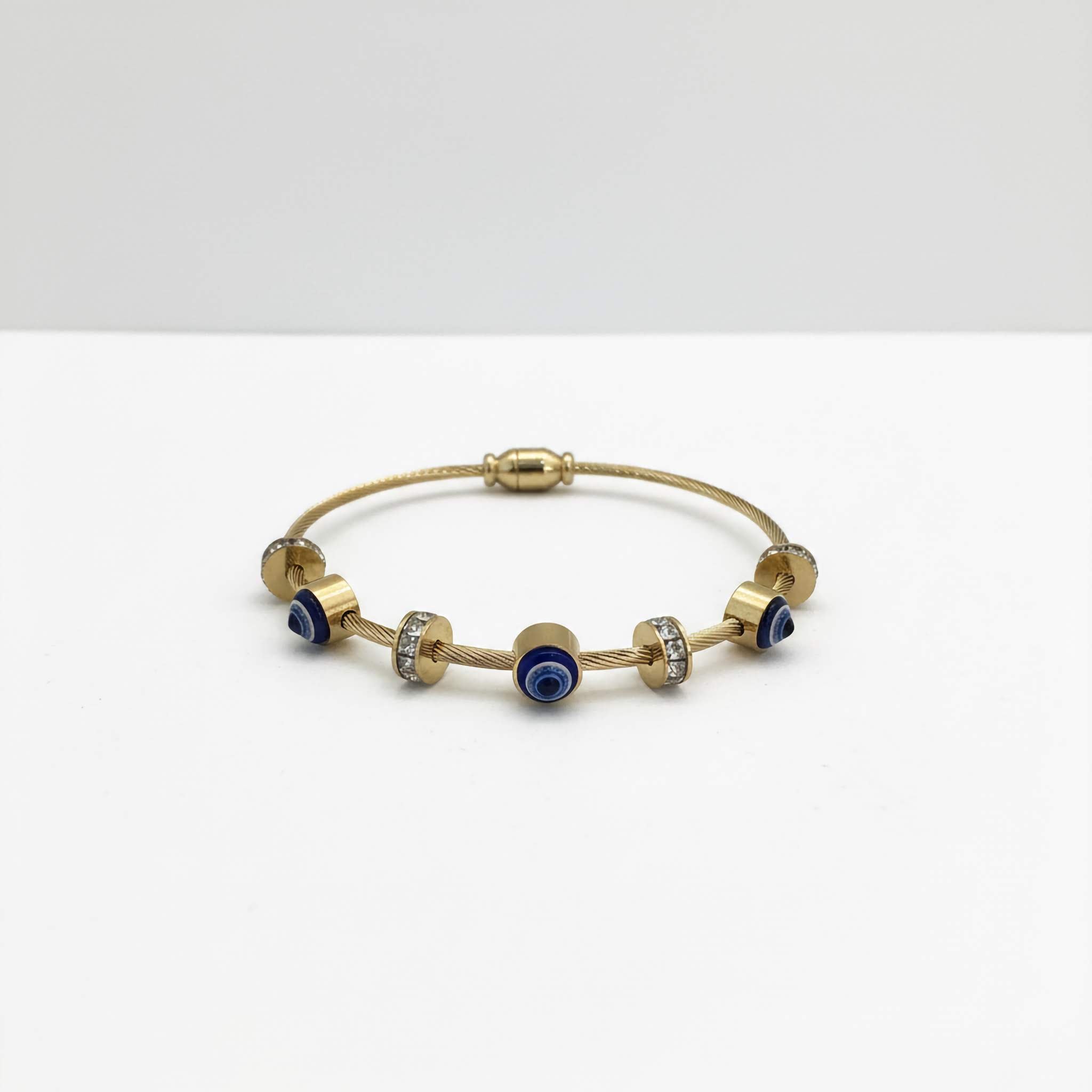 18k Gold plated bracelet with blue evil eye charms on a white background