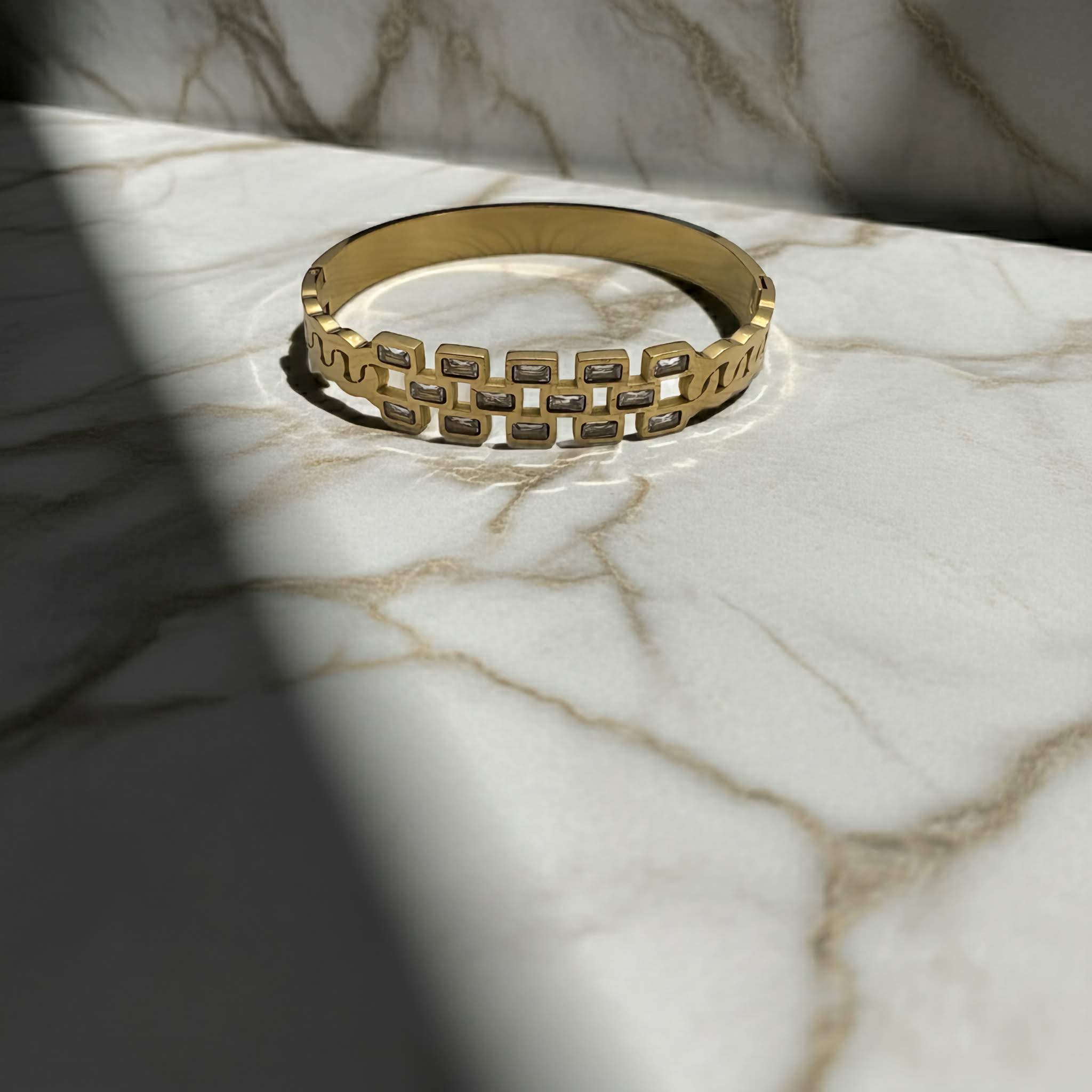 18k Gold plated bracelet with geometric design and zirconia diamonds on a marble surface