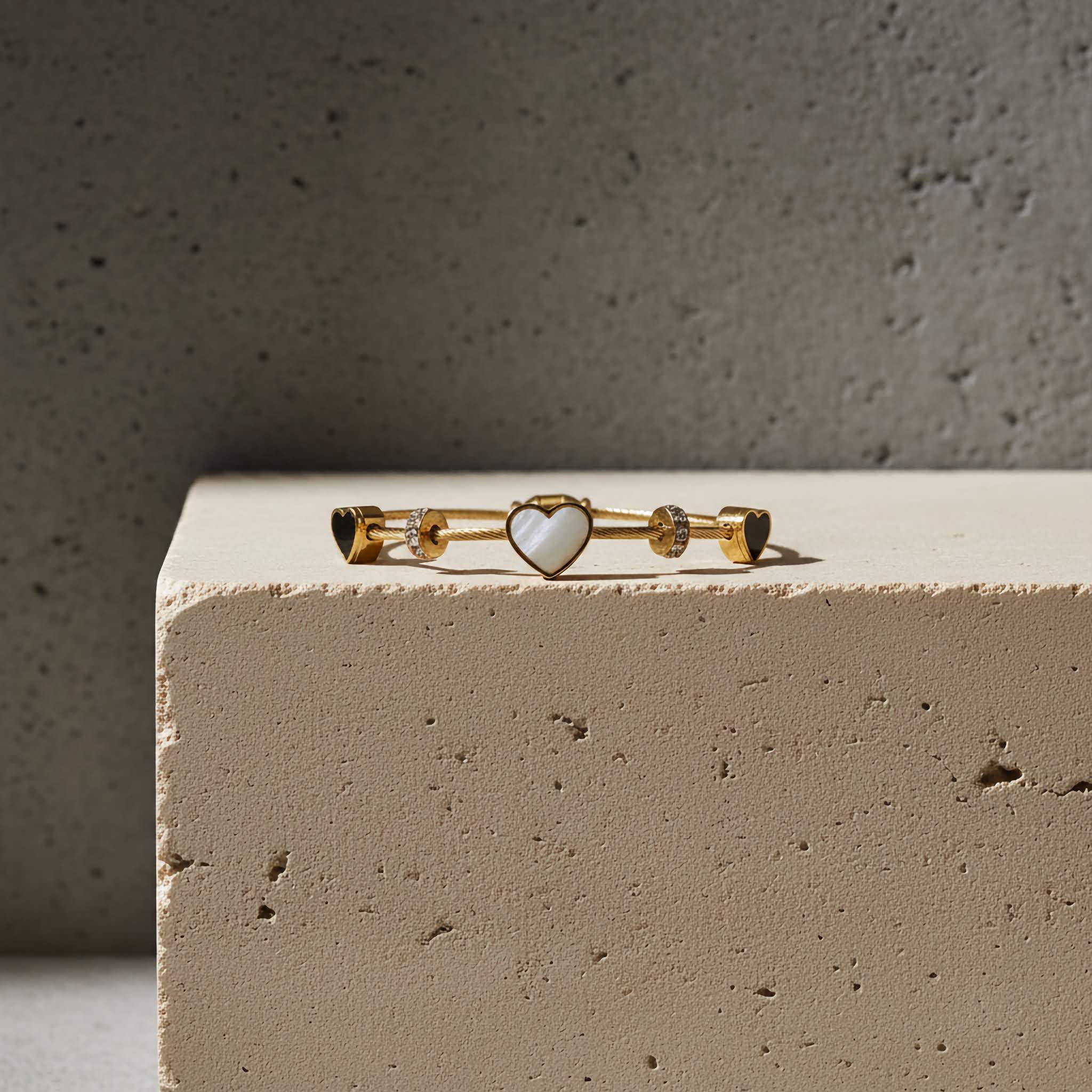 18k Gold plated bracelet with heart-shaped charm on a textured surface
