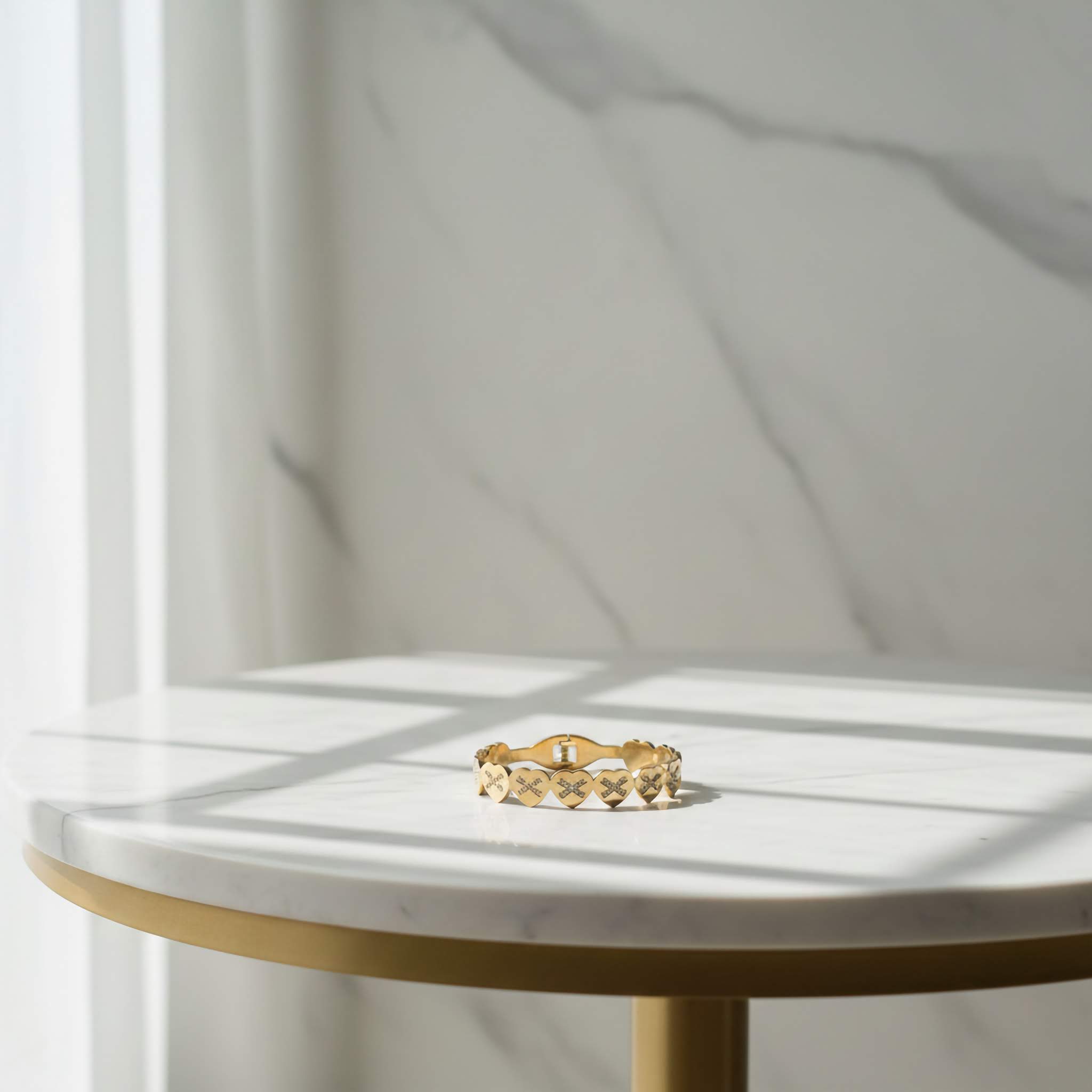 18k Gold plated bracelet with heart design on a marble surface with soft shadows