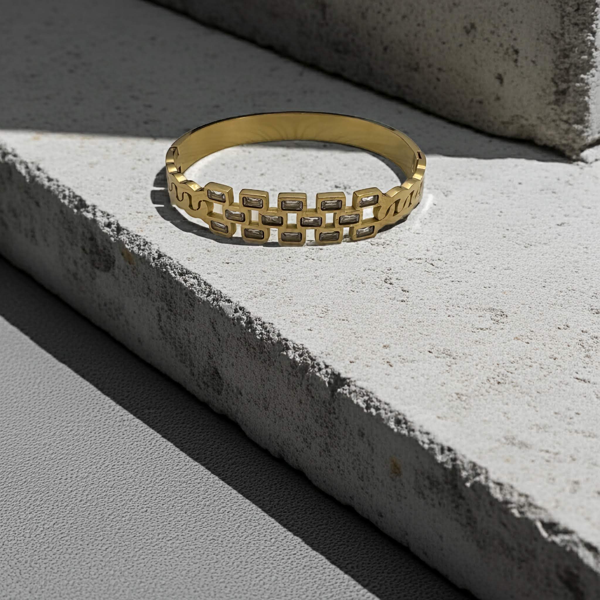 18k Gold plated chain-link bracelet on a concrete surface
