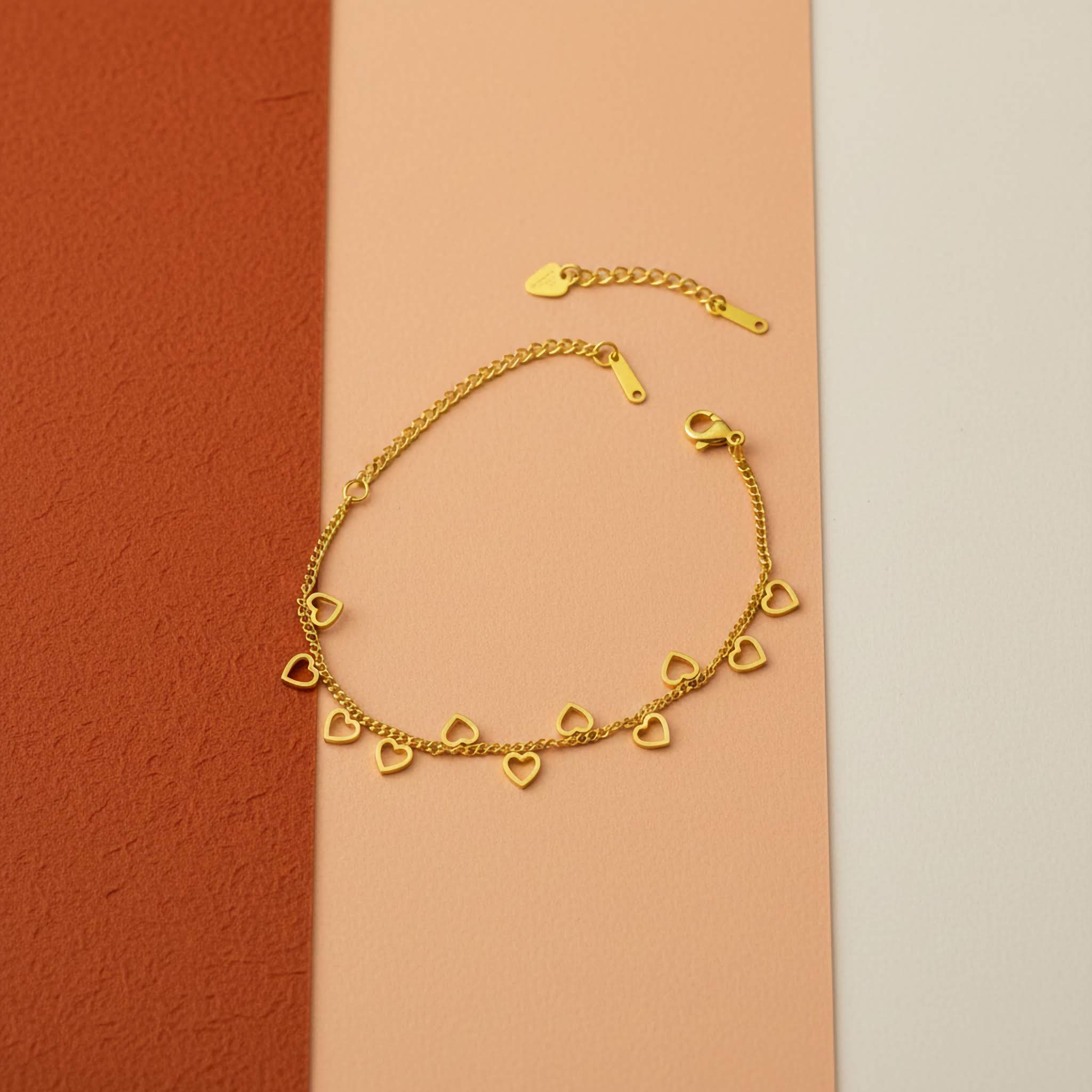 18k Gold plated mini heart-shaped bracelet on a multicolored background