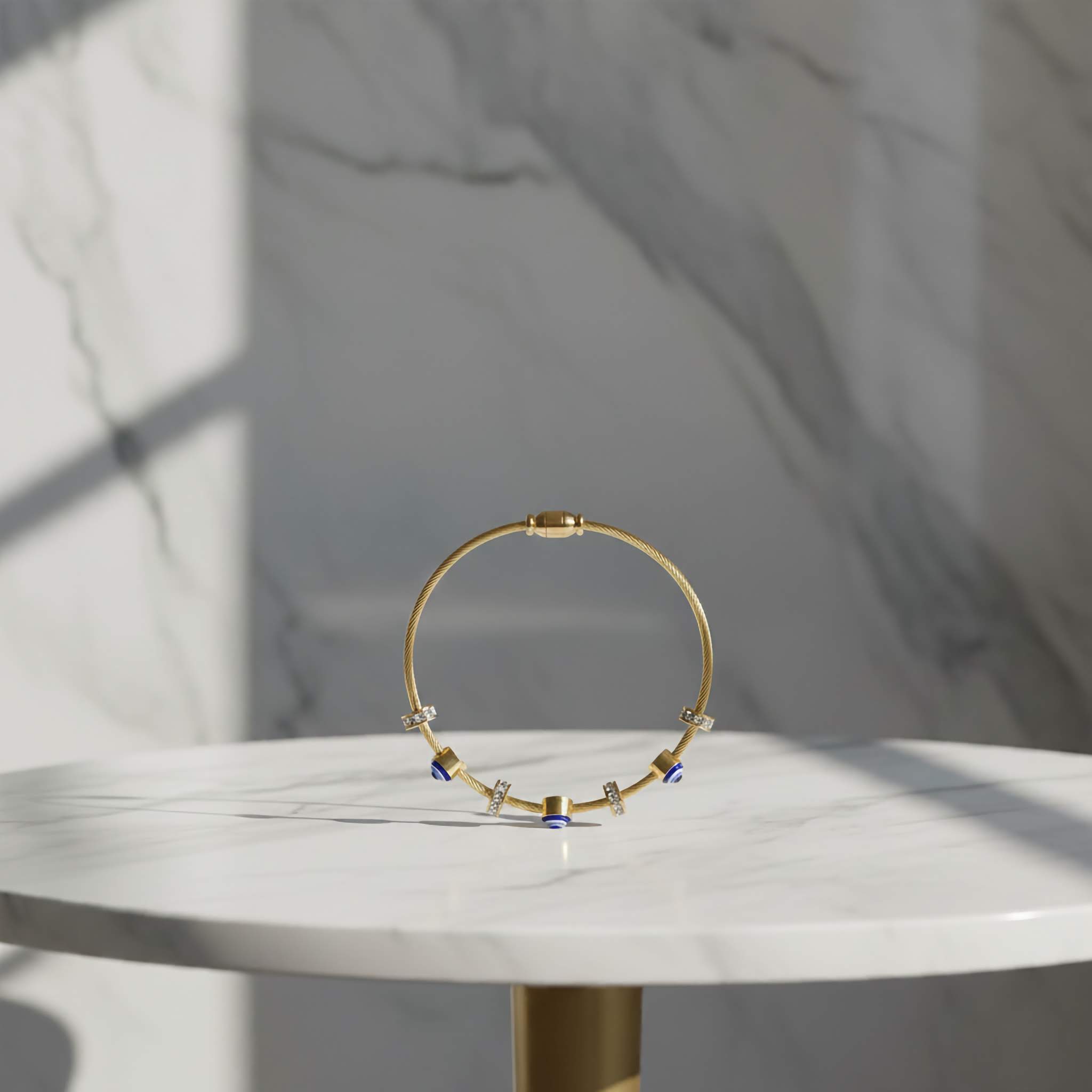 18k Gold plated necklace with blue accents evil eye charms on a marble surface