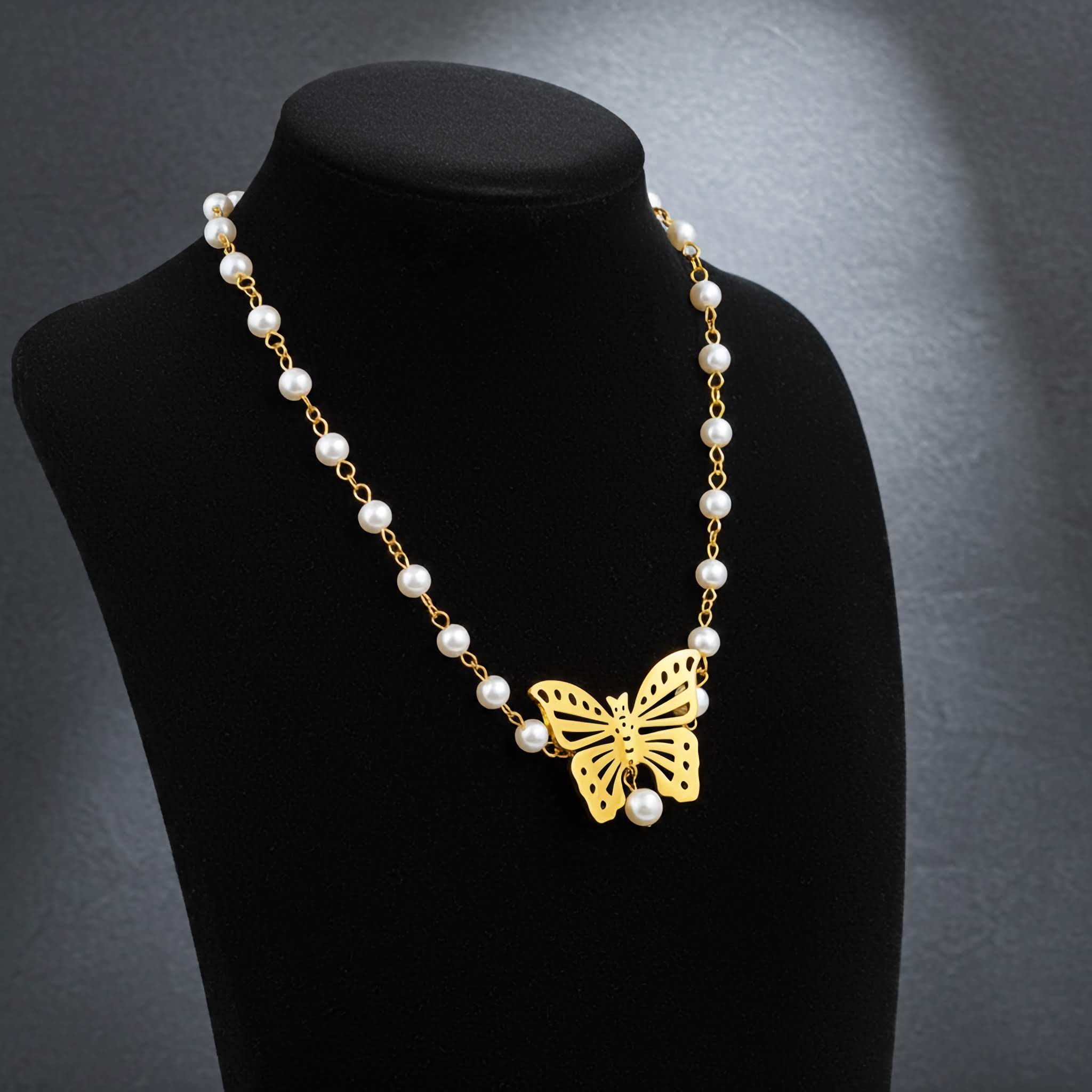 Pearl necklace with a gold butterfly pendant on a black mannequin against a dark background