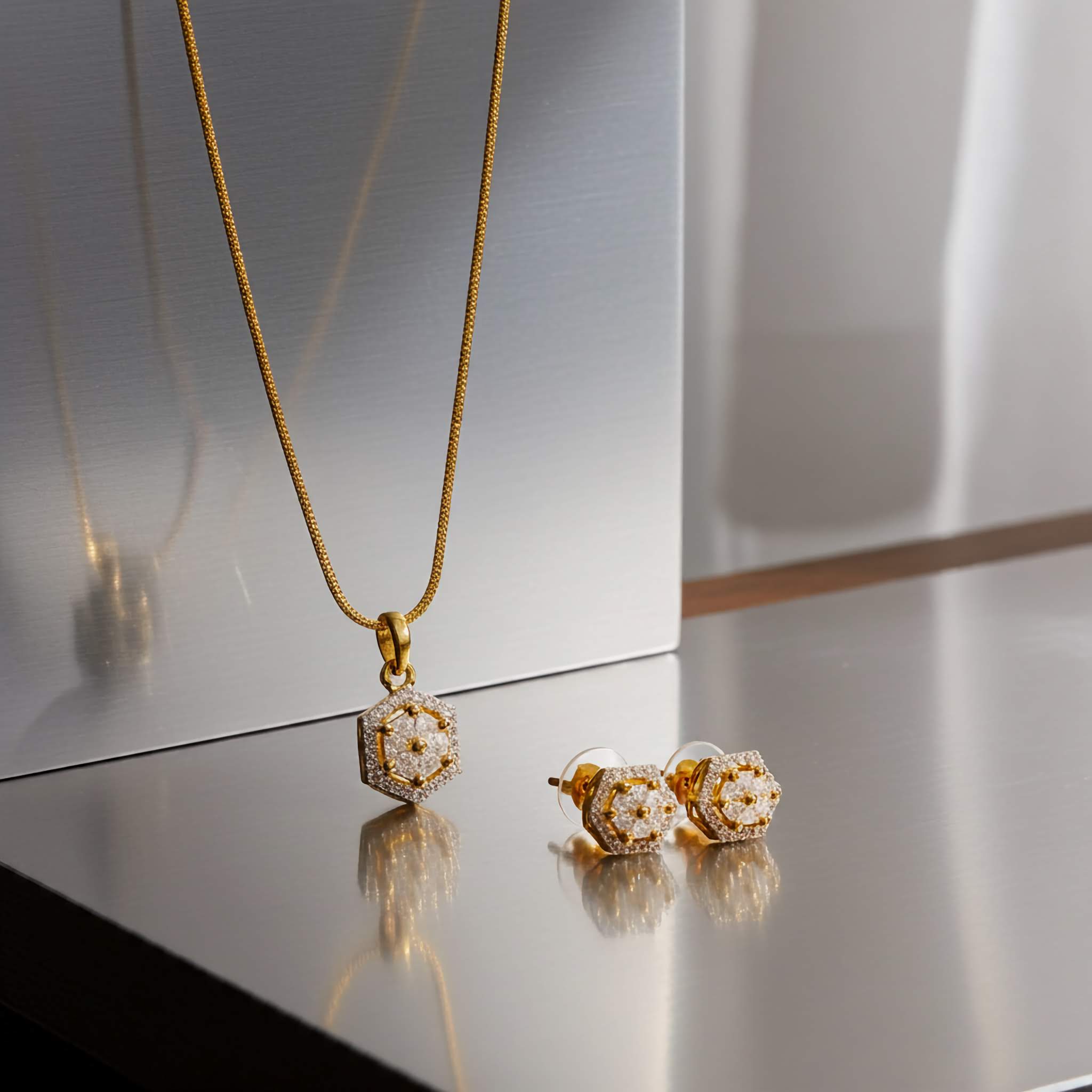 18k Gold plated necklace and earrings on a reflective surface