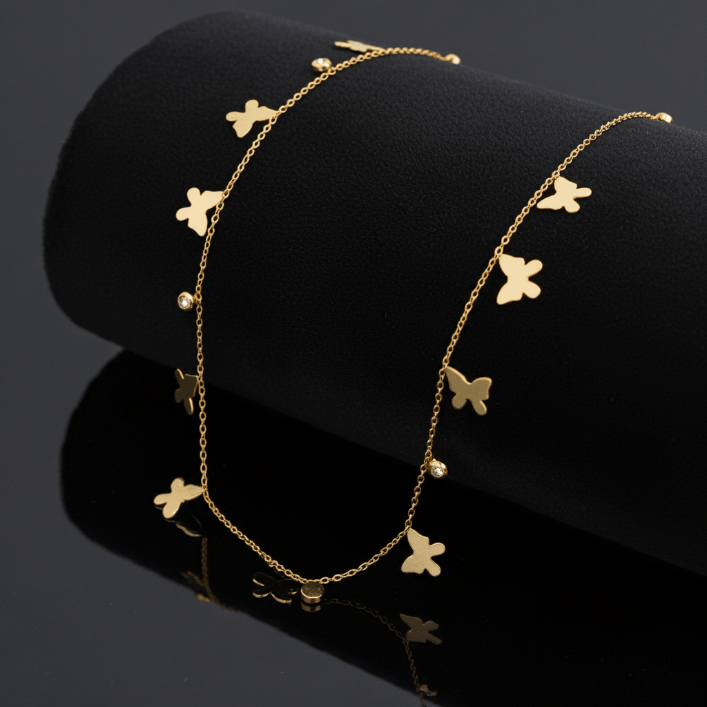 18k Gold bracelet with butterfly charms on a black background