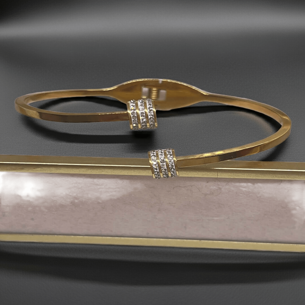 Gold bracelet with diamond accents on a reflective surface