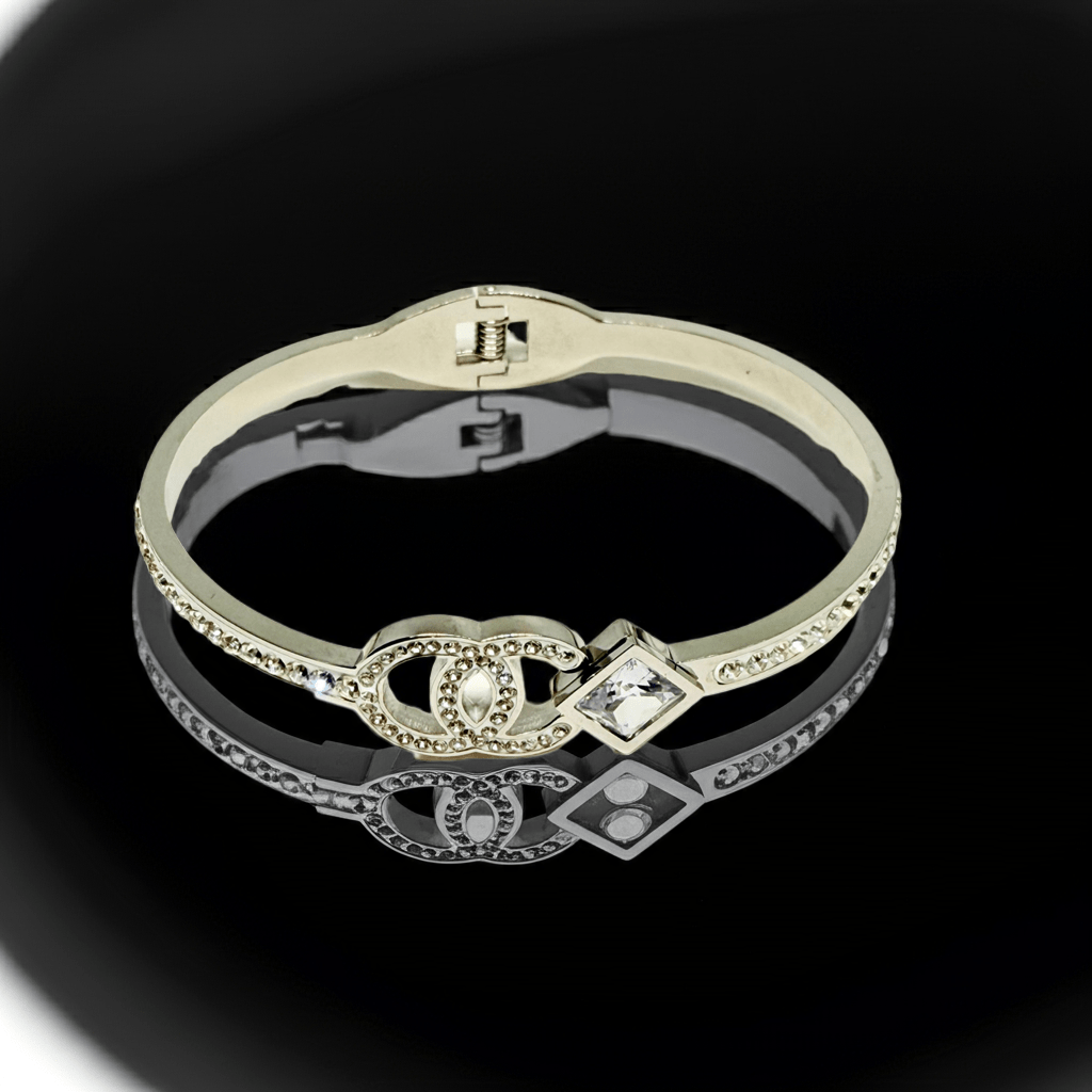 Gold bracelet with a central gemstone on a black background