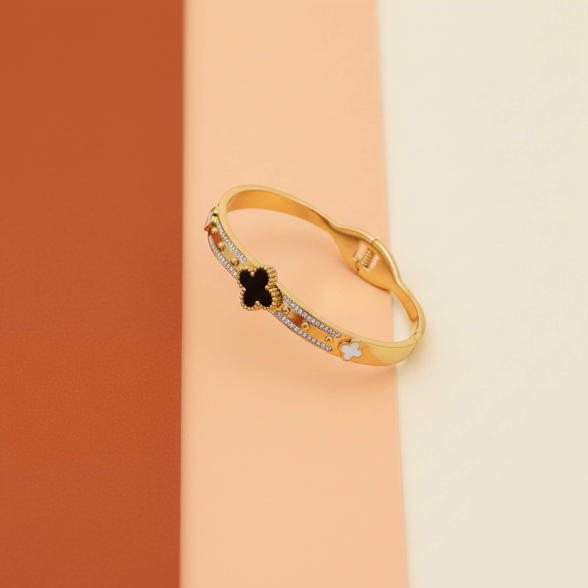 Black and white clover leaf bracelet on a tri-colour background