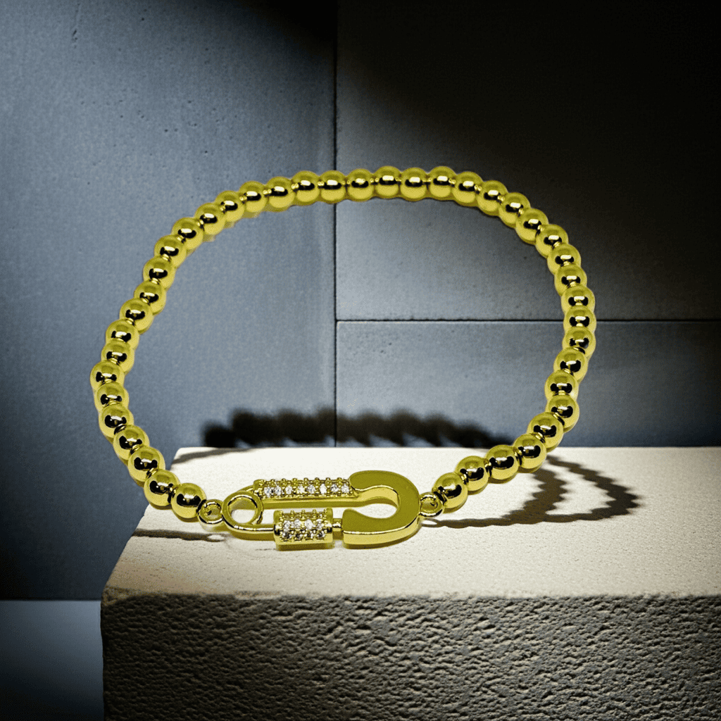 Slip on beaded Gold bracelet with a clasp on a textured surface