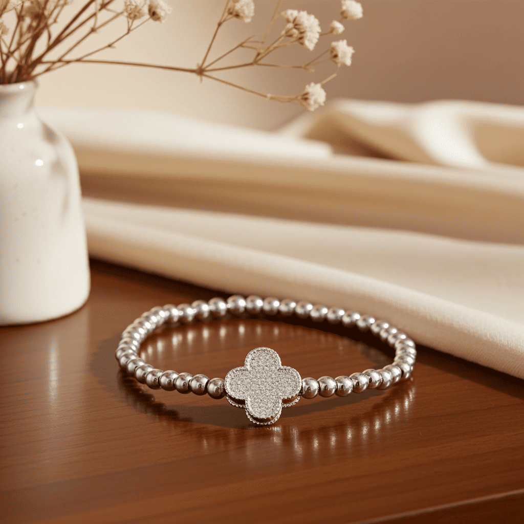 Buy Silver slip-on bracelet with clover-shaped charm on a wooden surface with a neutral background