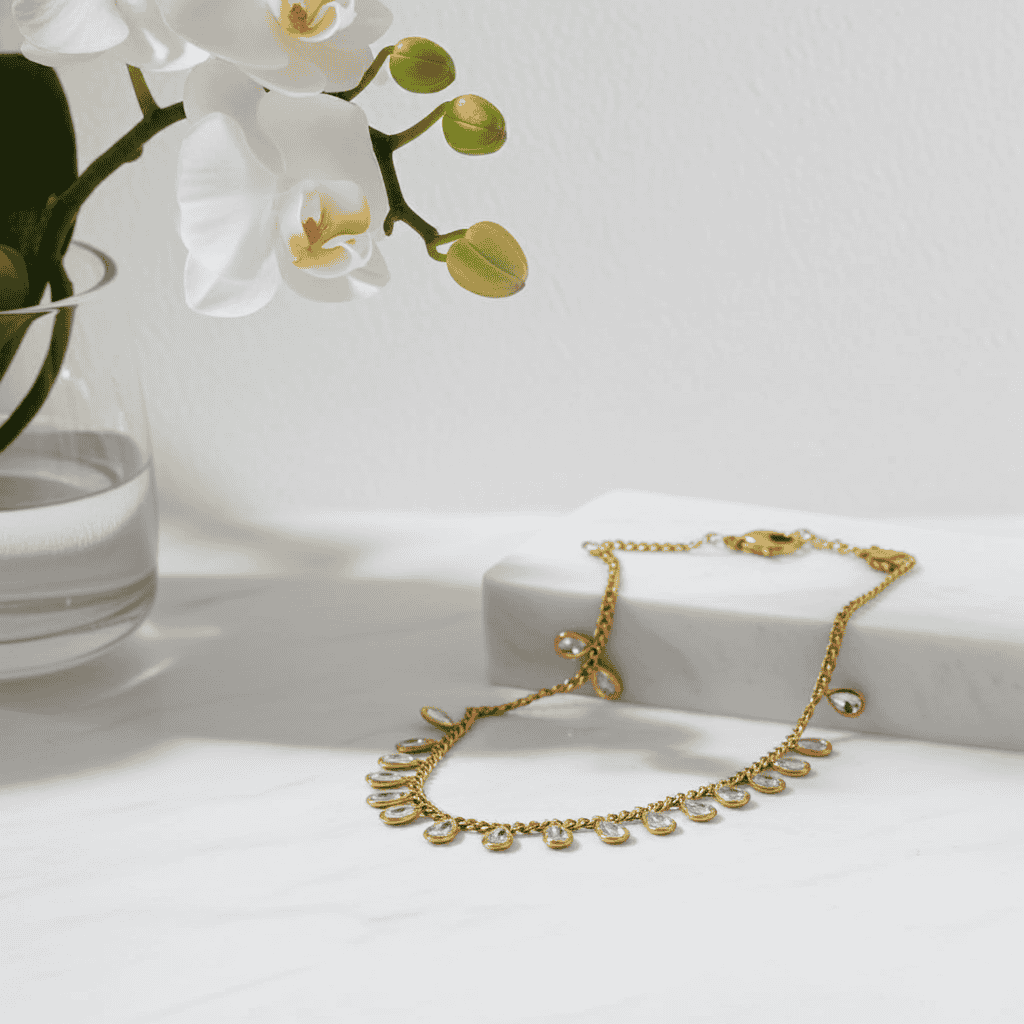 Buy Gold plated cubic zirconia necklace on a white surface with a vase of white orchids in the background