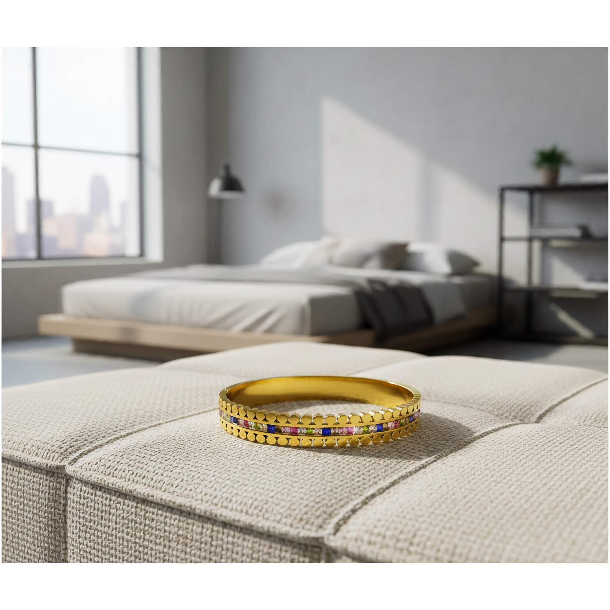 Everyday wear Gold bracelet with colorful stones on a beige ottoman in a modern bedroom.