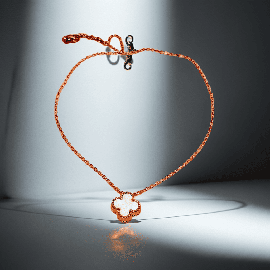 Gold Necklace with a clover-shaped pendant on a reflective surface