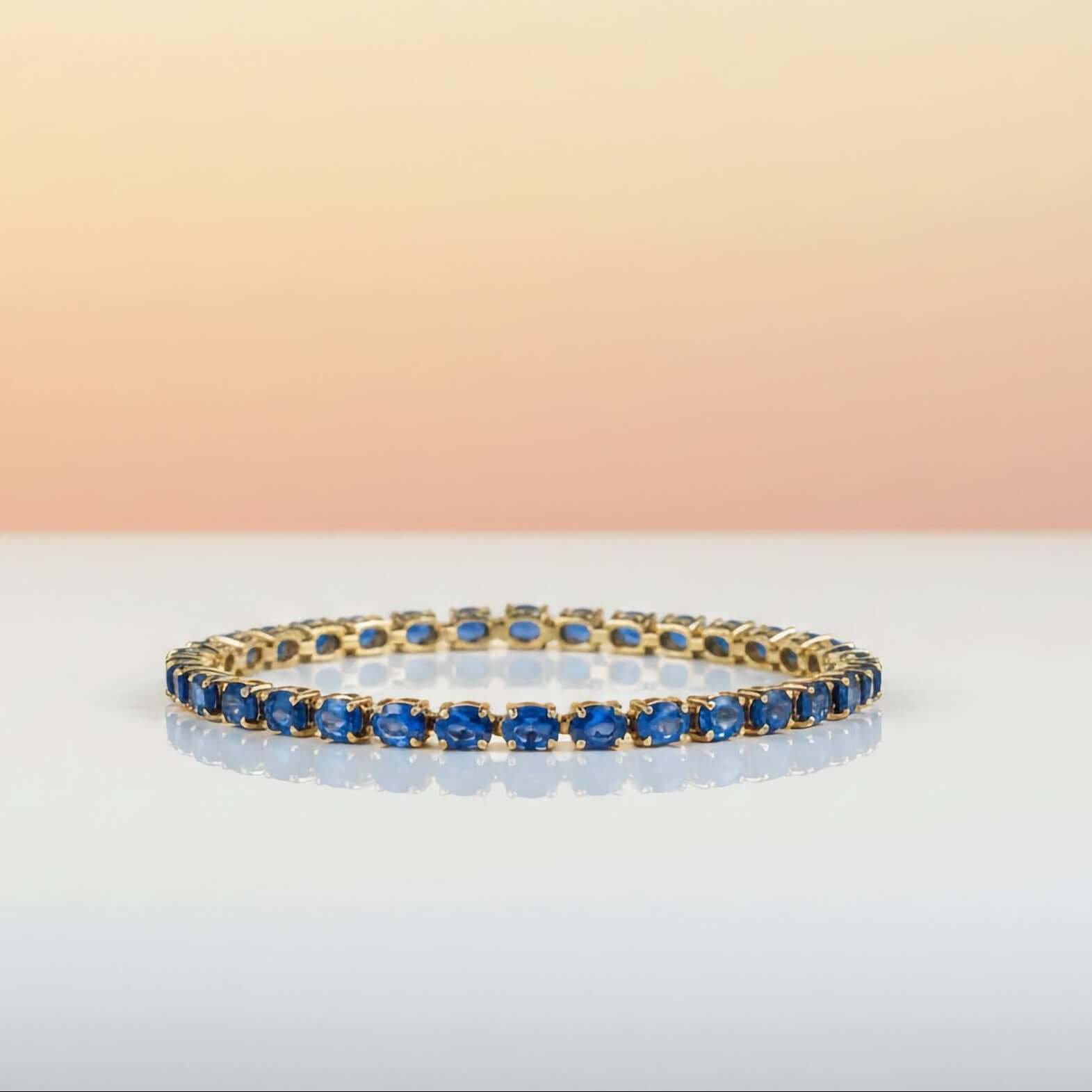 Luxury Statement Jewelry Bracelets Gold bracelet with blue stones on a gradient background