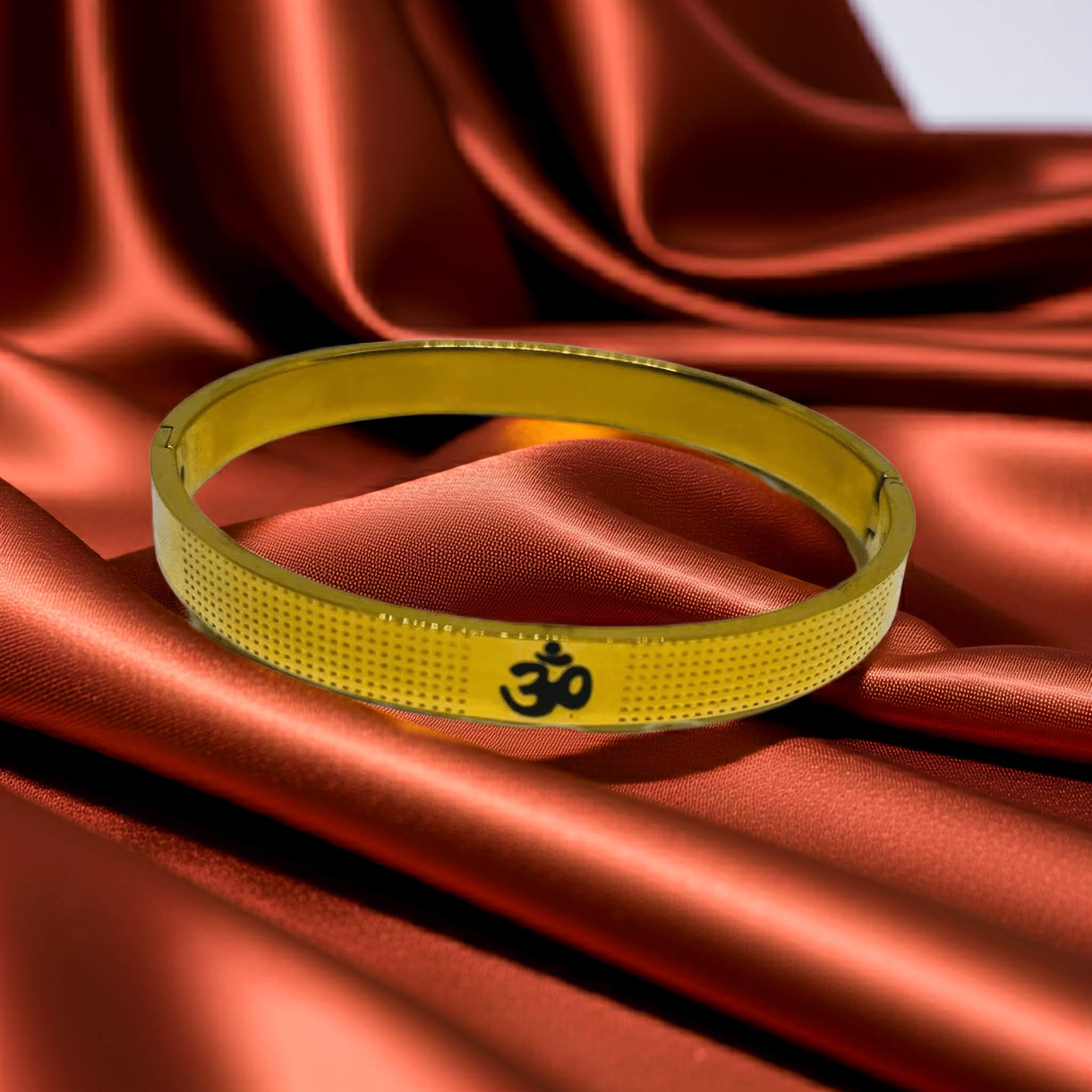 Gold plated bracelet with a symbol on red fabric
