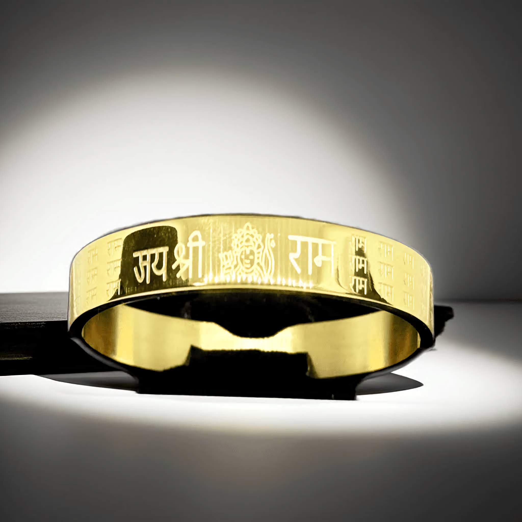A Gold Ram bangle with engraved Jai Shree Ram text on a dark background