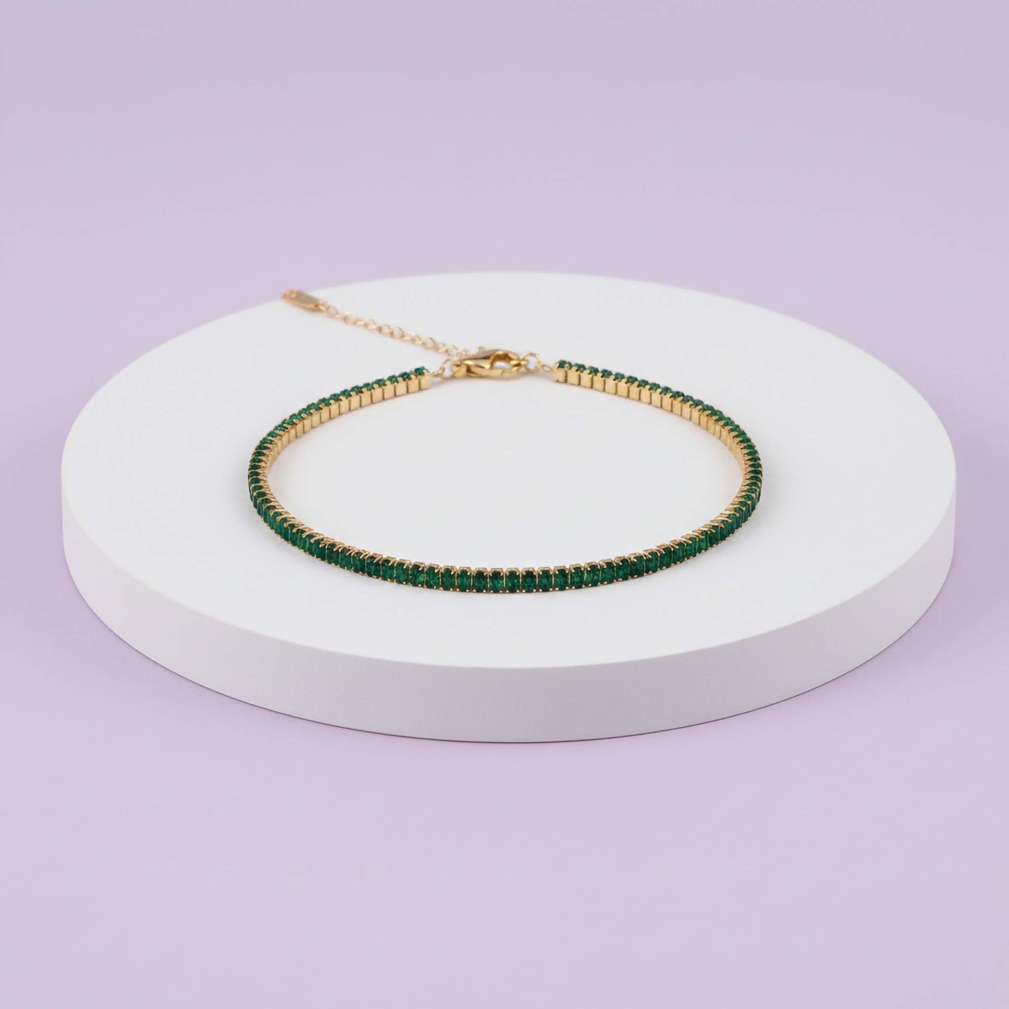 Green beaded bracelet on a white stand with a light purple background