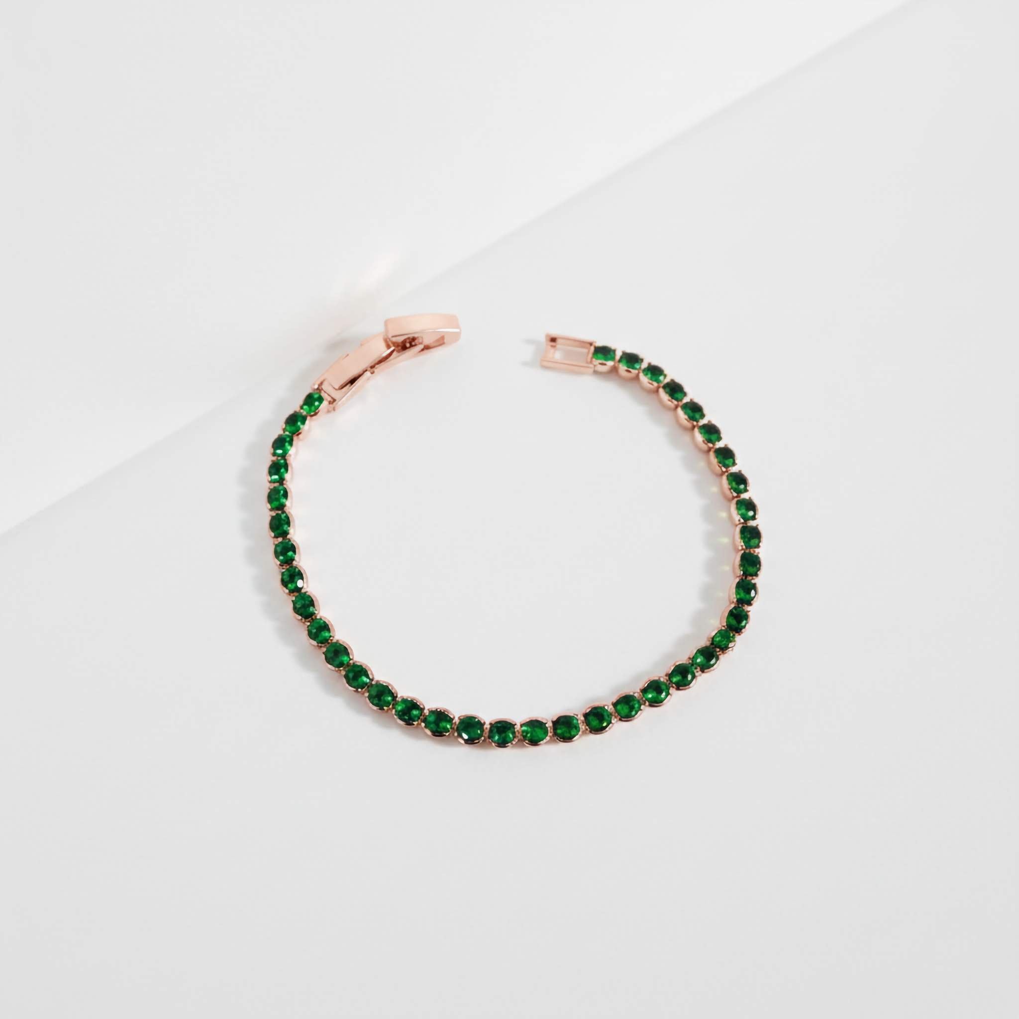 Green gemstone bracelet with rose gold clasp on a light gray background