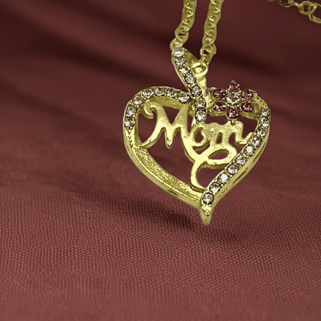 18k Gold heart-shaped pendant with 'Mom' engraving on a brown fabric background