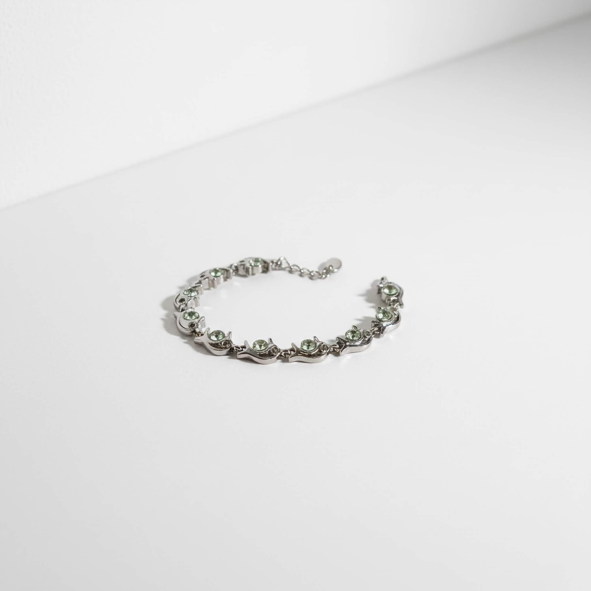 Oxidized bracelet with light green stones on a white background