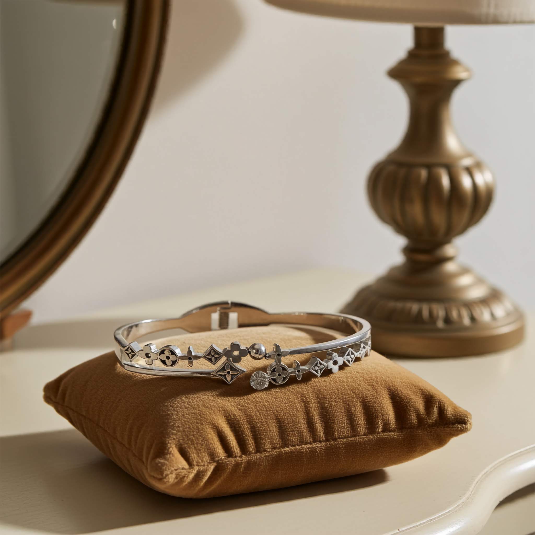 Oxidized Silver bracelet on a brown pillow with a blurred lamp and mirror in the background