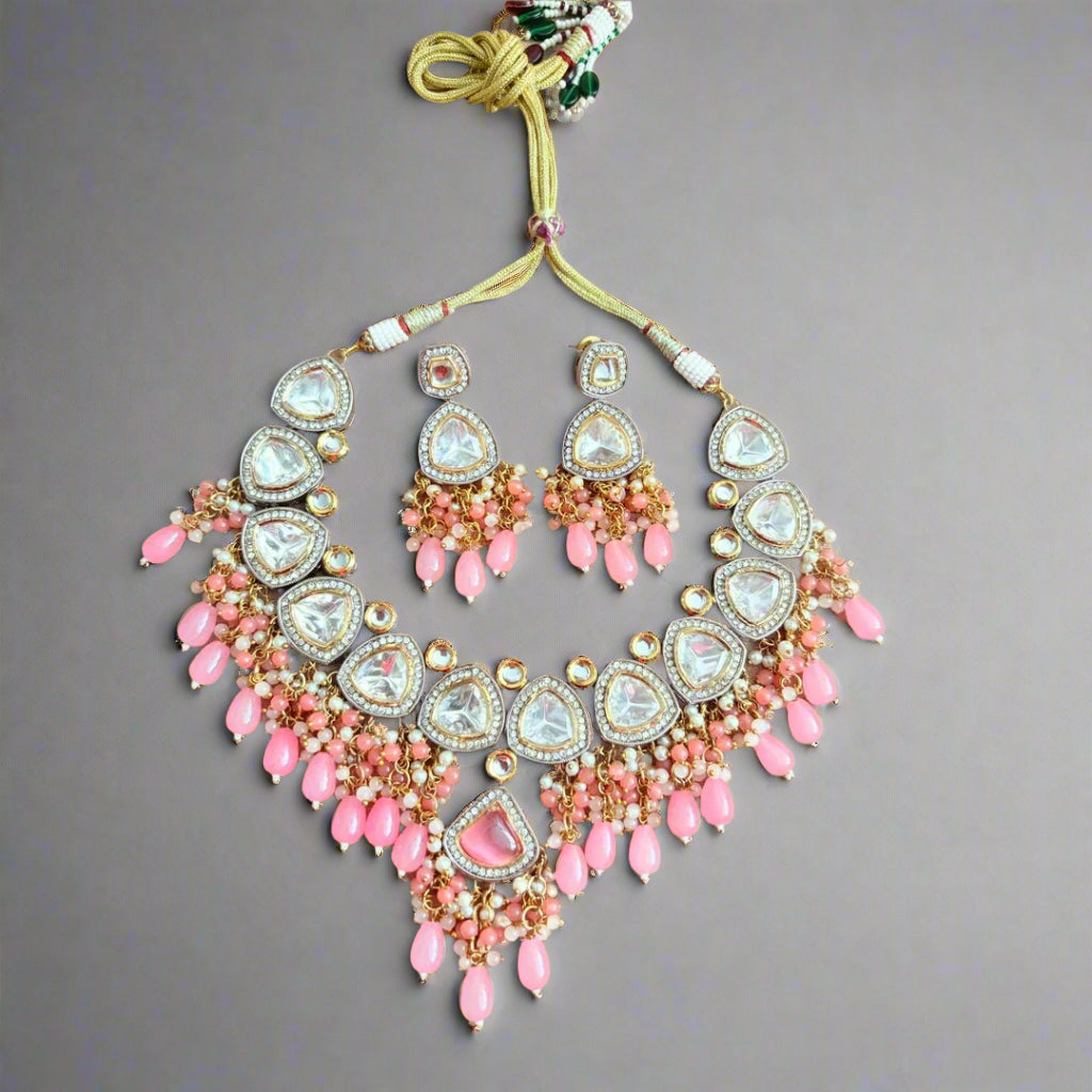 Ornate necklace with pink beads on a beige background