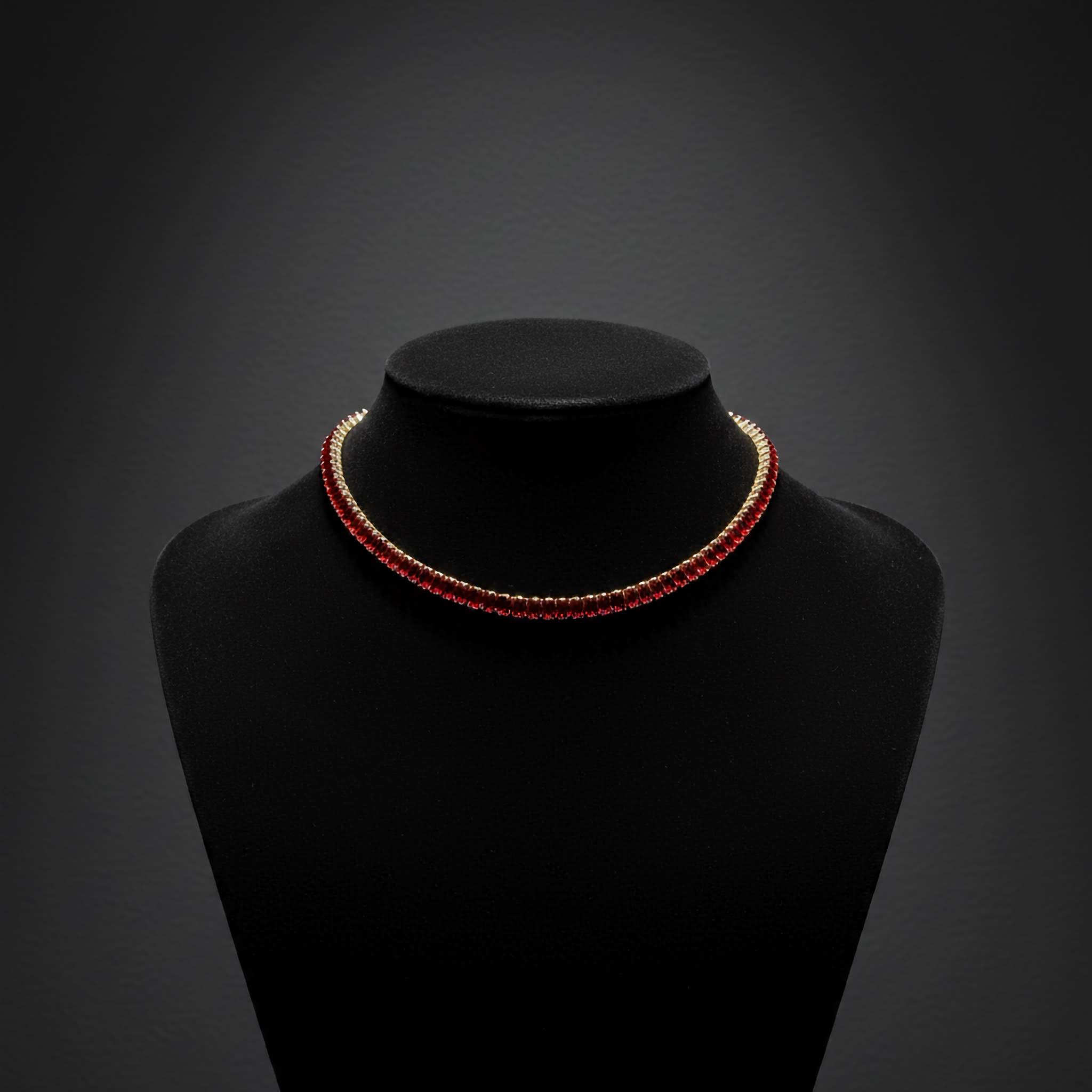Red crystal tennis necklace on a black mannequin bust against a dark background