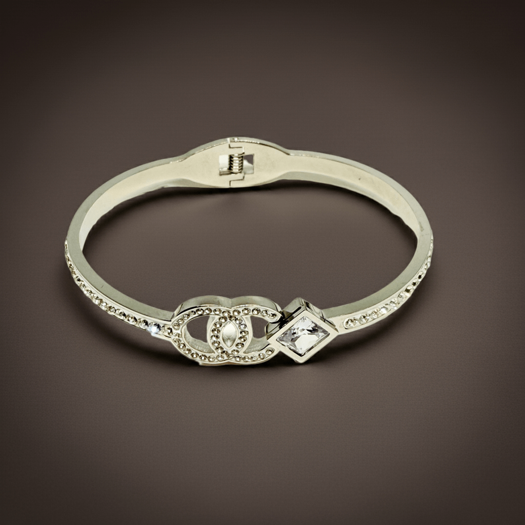 Silver bracelet with decorative clasp and crystals on a brown background