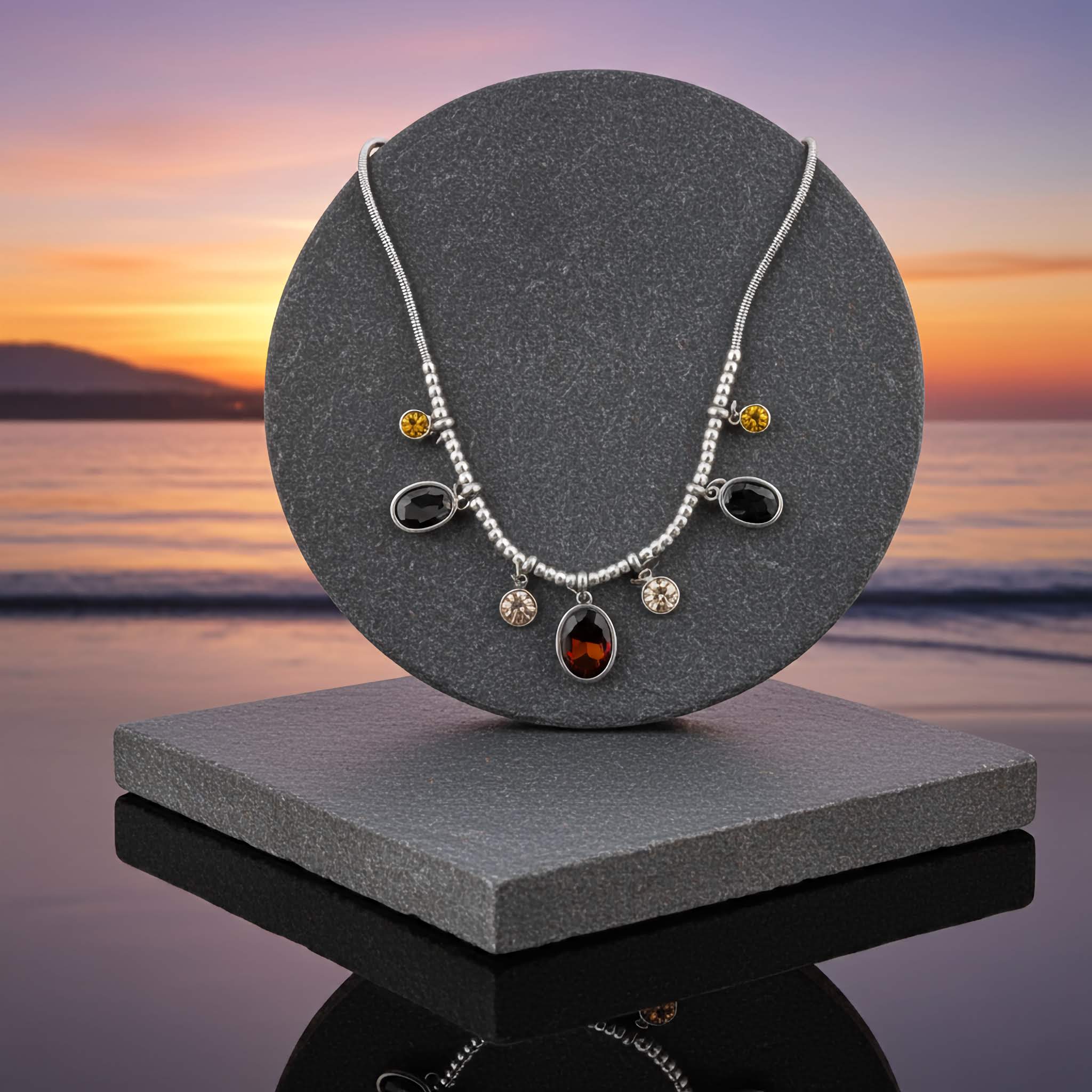 $10 Silver plated Necklace on a gray stand with a sunset over water background