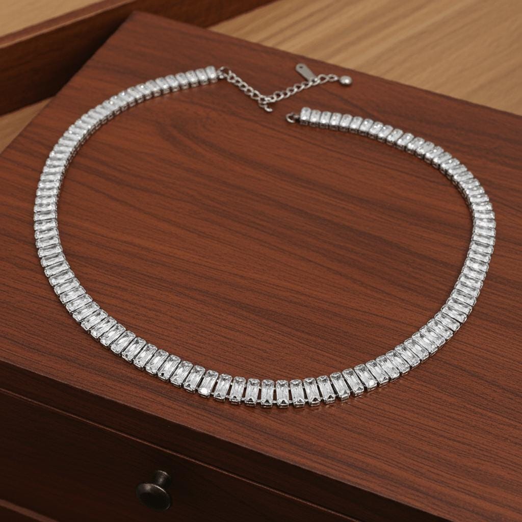 Silver tennis necklace with clear stones on a wooden surface