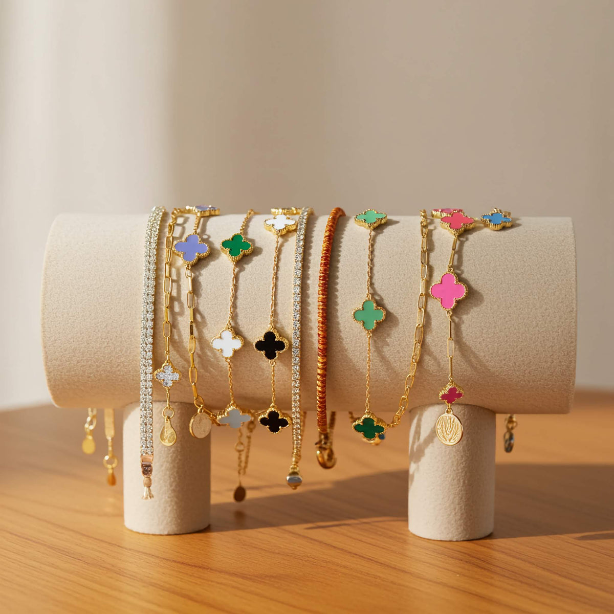 Set of colorful clover bracelets on a wooden surface with a neutral background