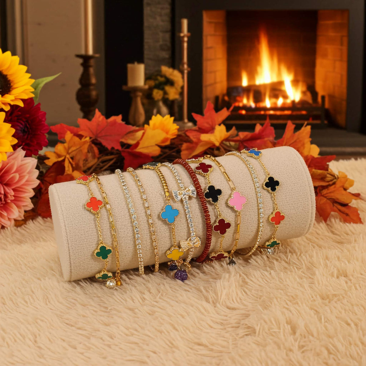 Roll of bracelets with multi color clover charms on a surface with a fireplace and flowers in the background
