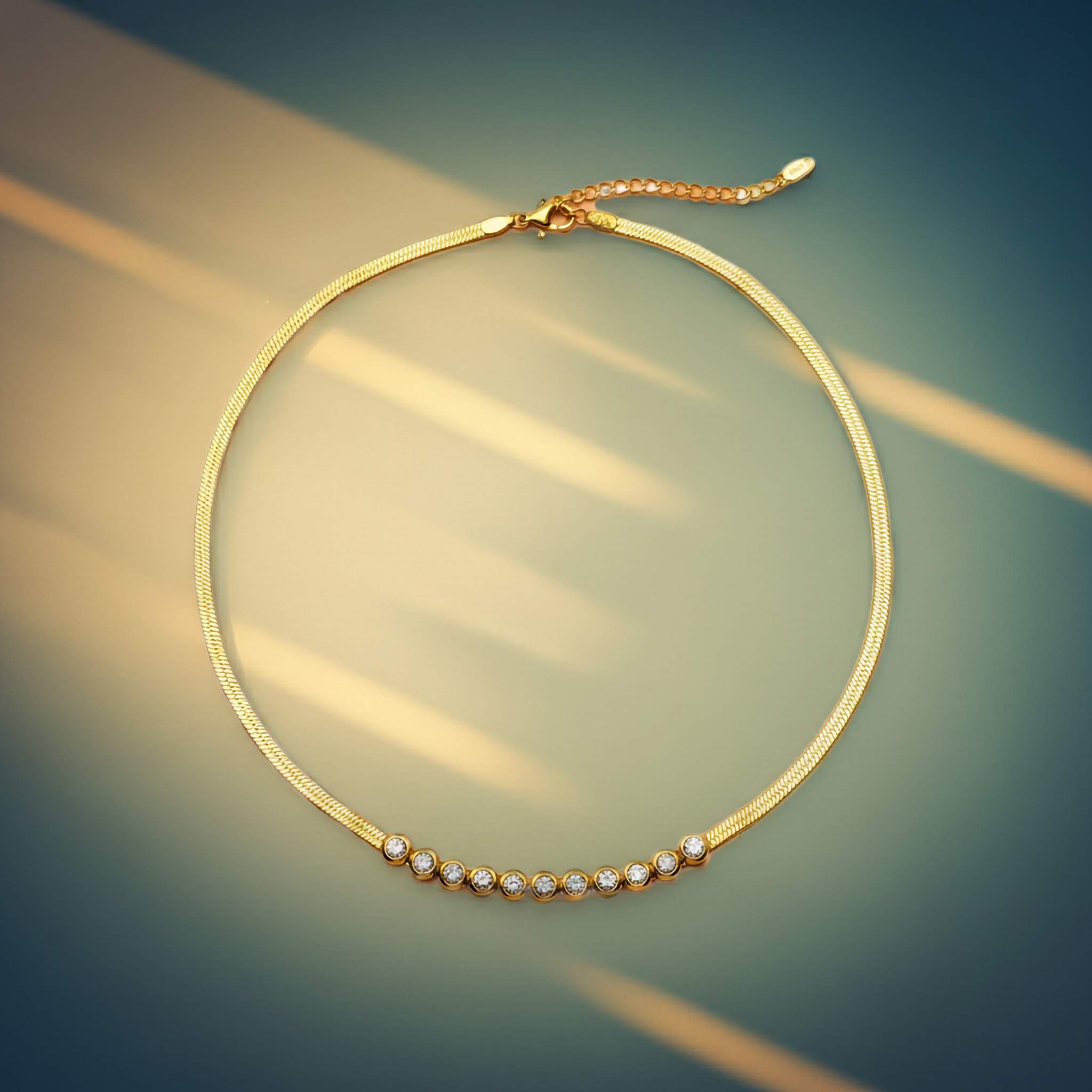 Gold necklace with small zirconia diamonds on a blurred background