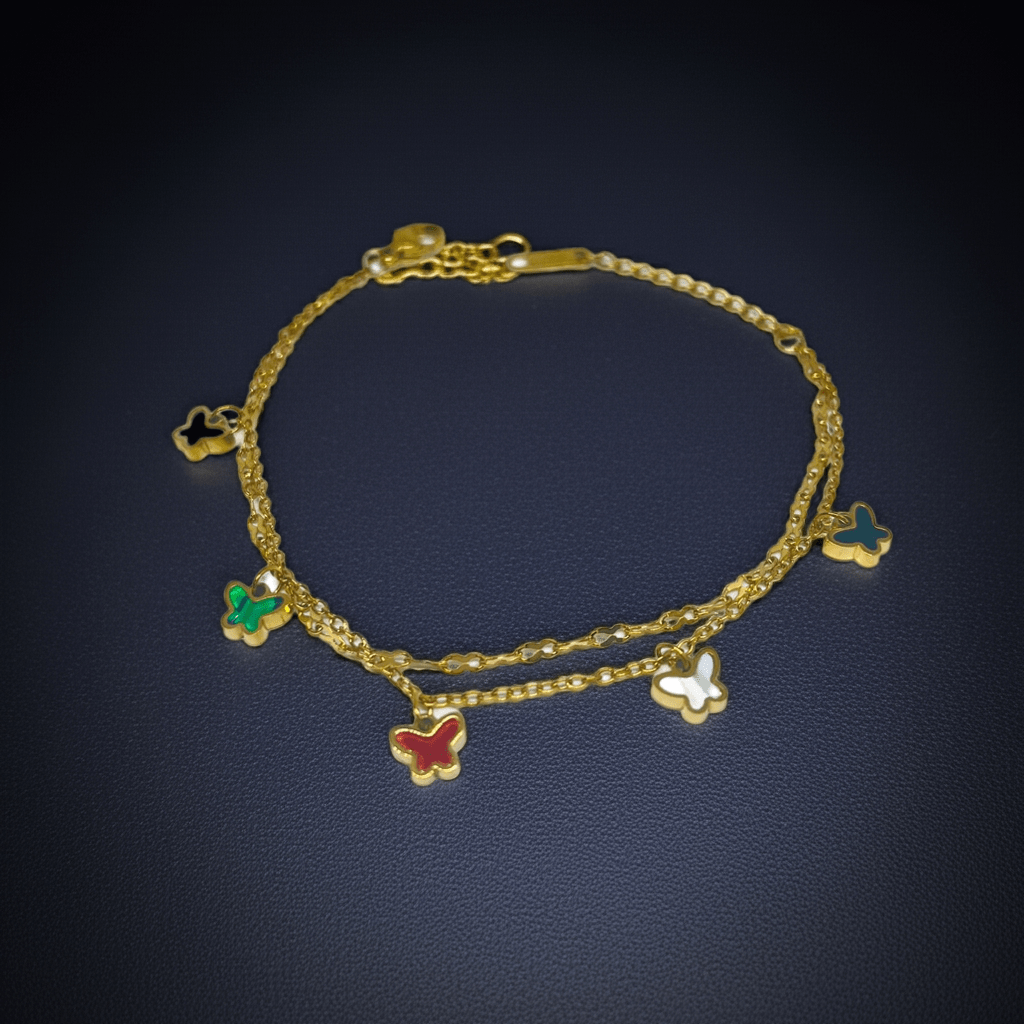 Gold bracelet with butterfly charms on a dark background