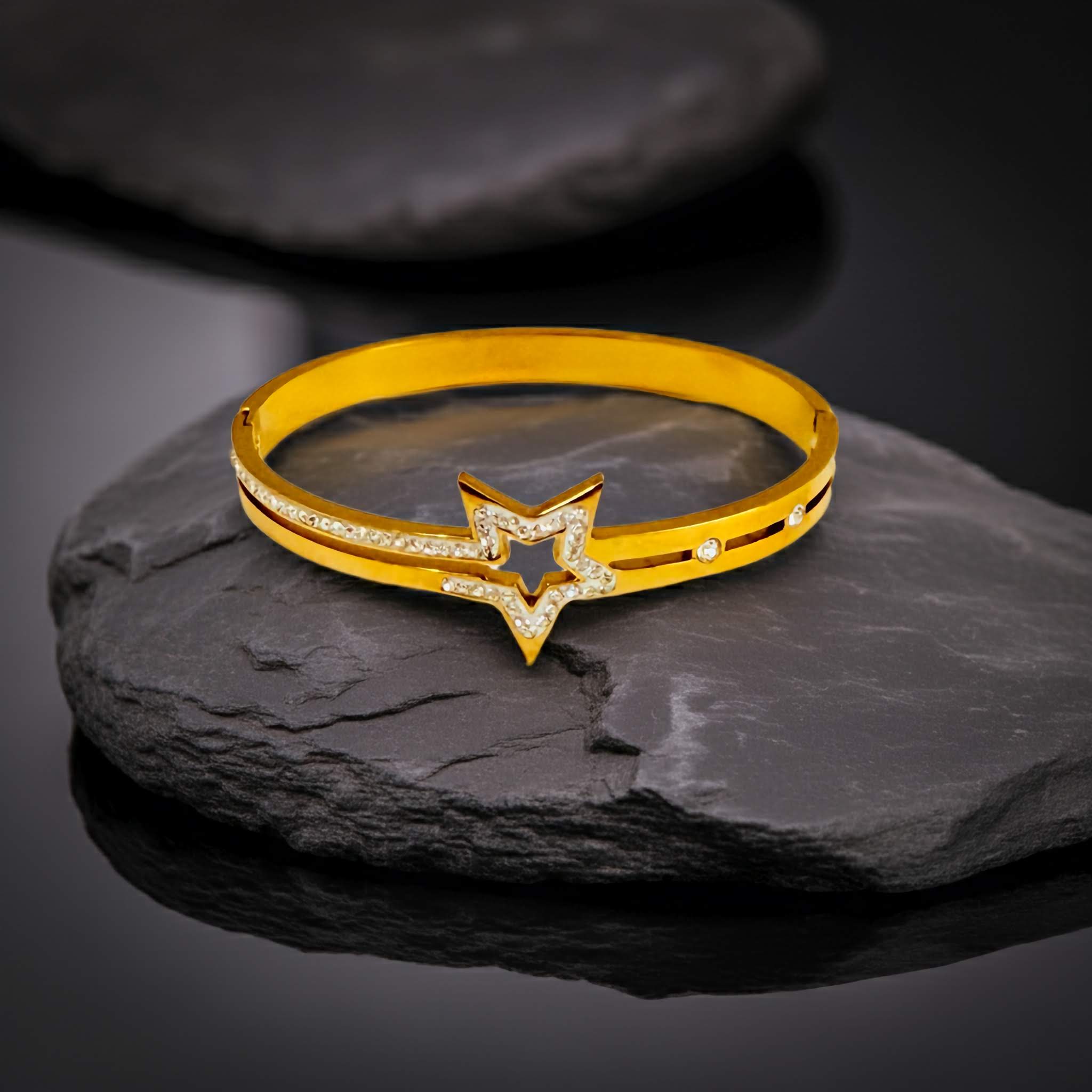 18k Gold bracelet with star design on a dark stone surface