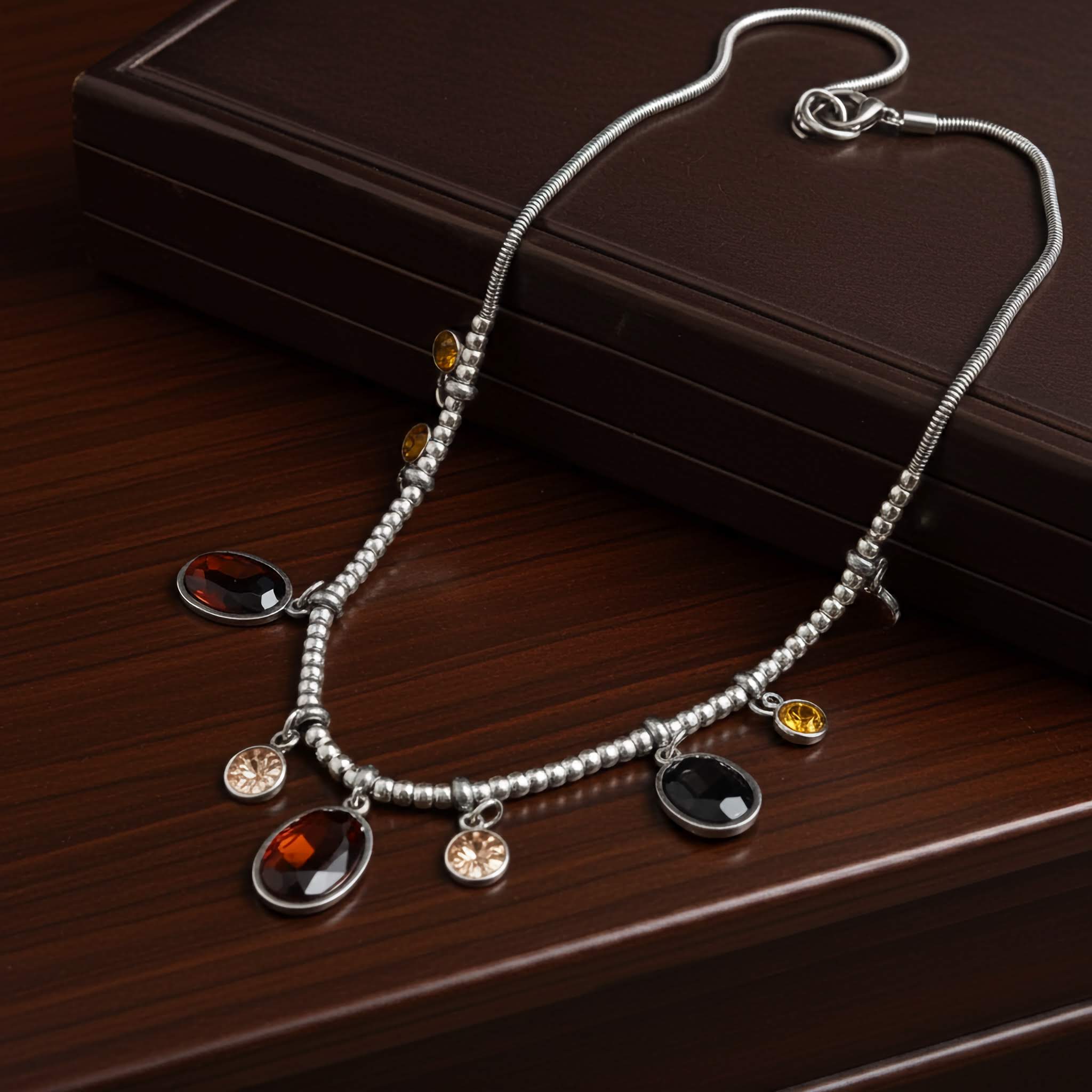 A $10 jewelry Silver plated necklace with colorful gemstone charms on a wooden surface