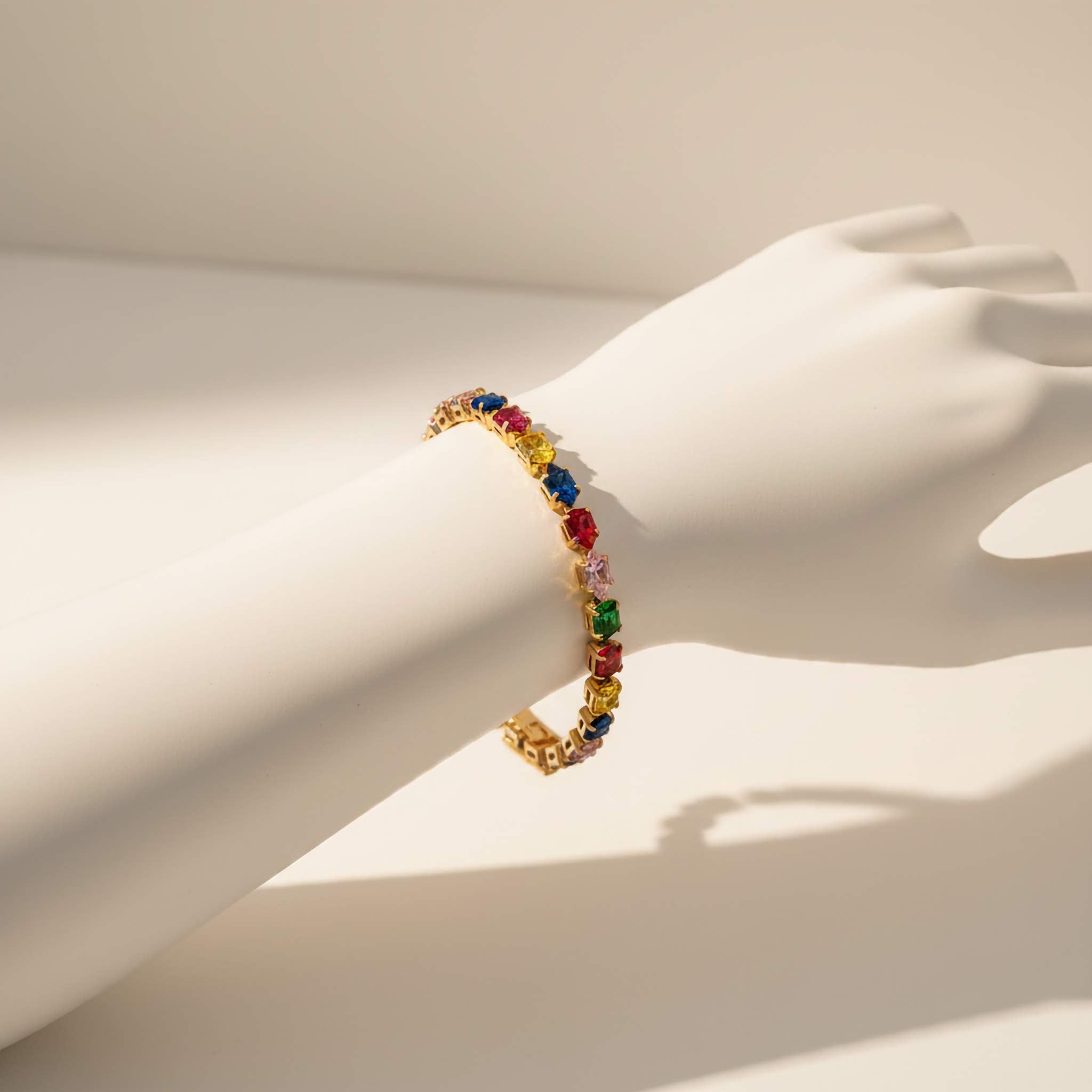 Multicolored crystal bracelet on a mannequin wrist against a neutral background