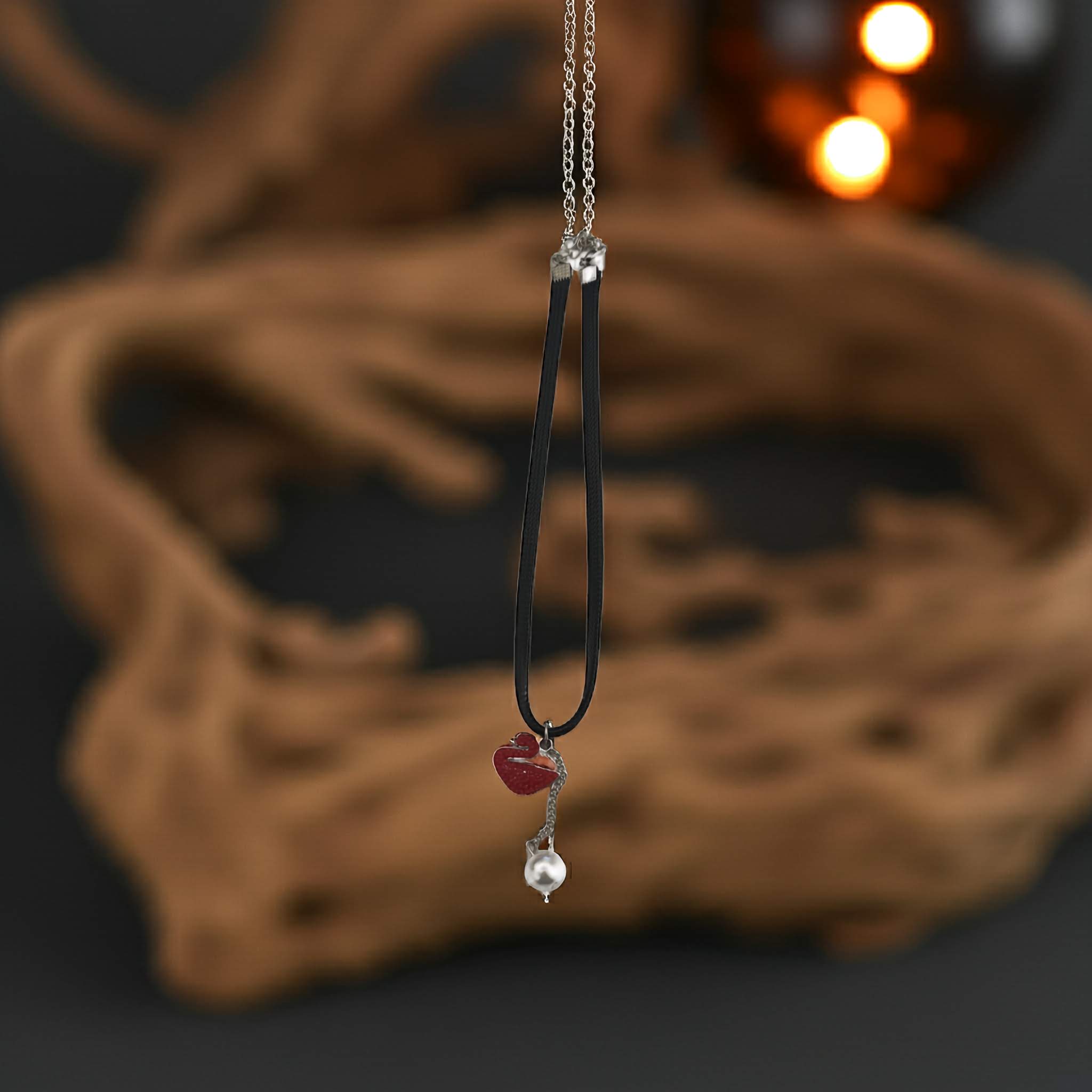 Necklace with heart and pearl pendant on a dark background