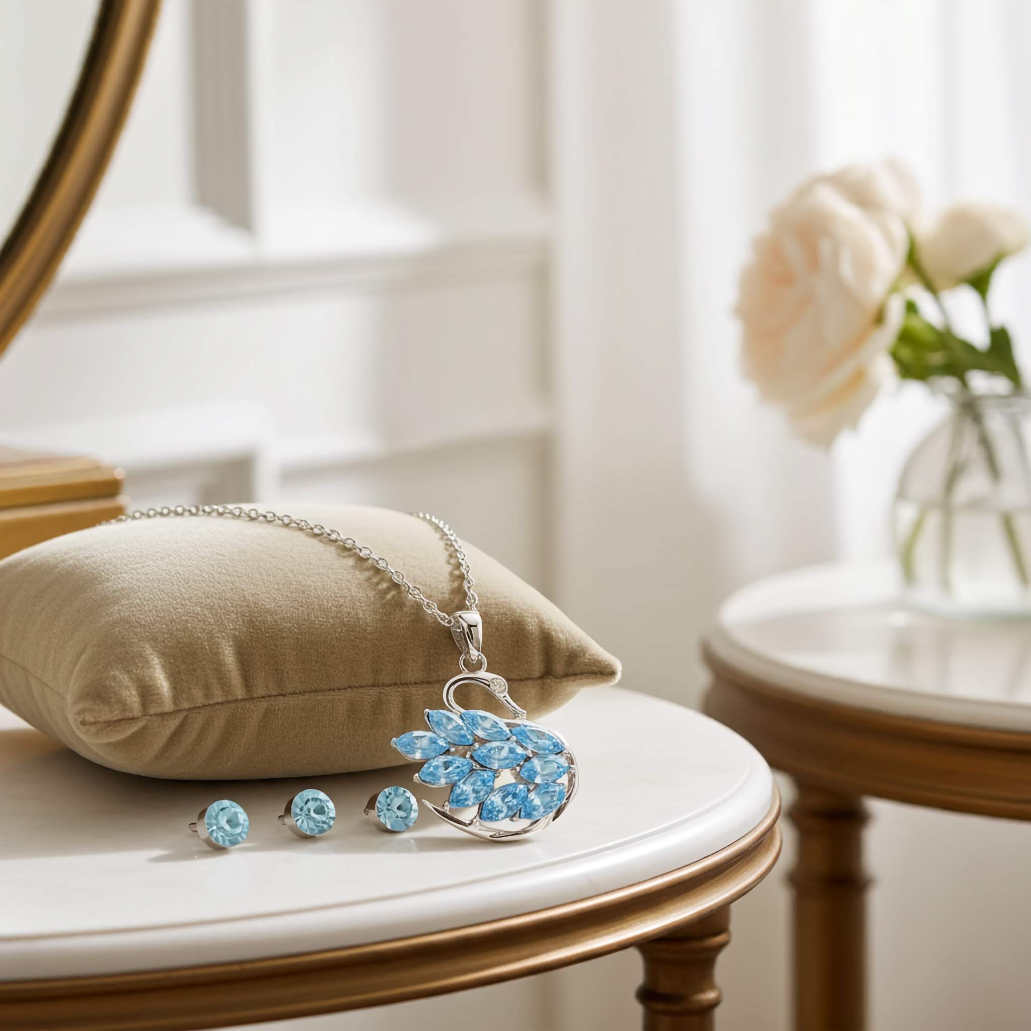 A silver Jewelry set with swan blue stones on a cushioned chair with a blurred background