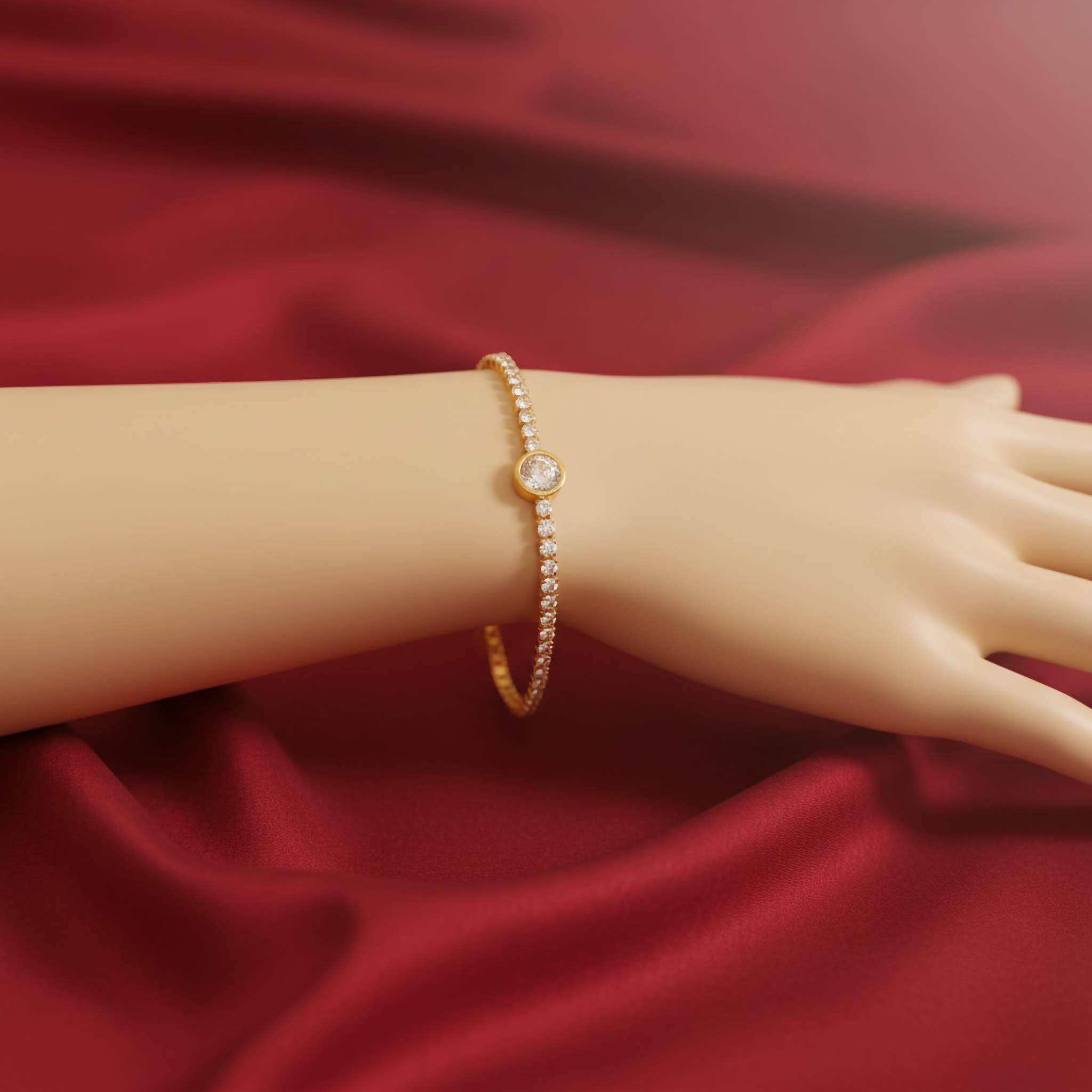 Gold plated white tennis bracelet on a mannequin hand against a red fabric background