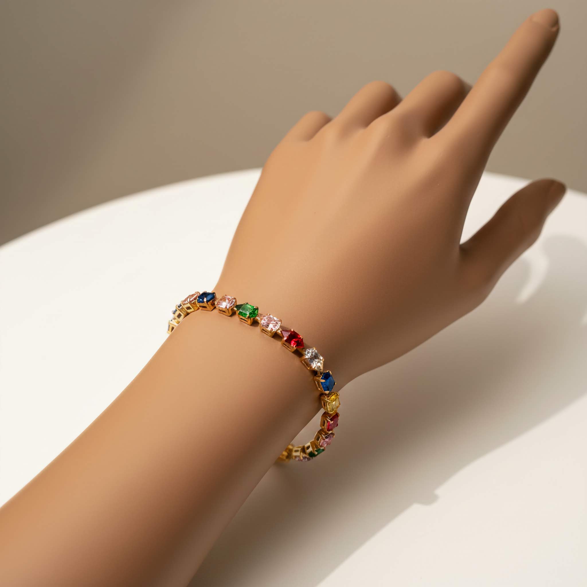 Multicolored gemstone bracelet on a hand against a neutral background
