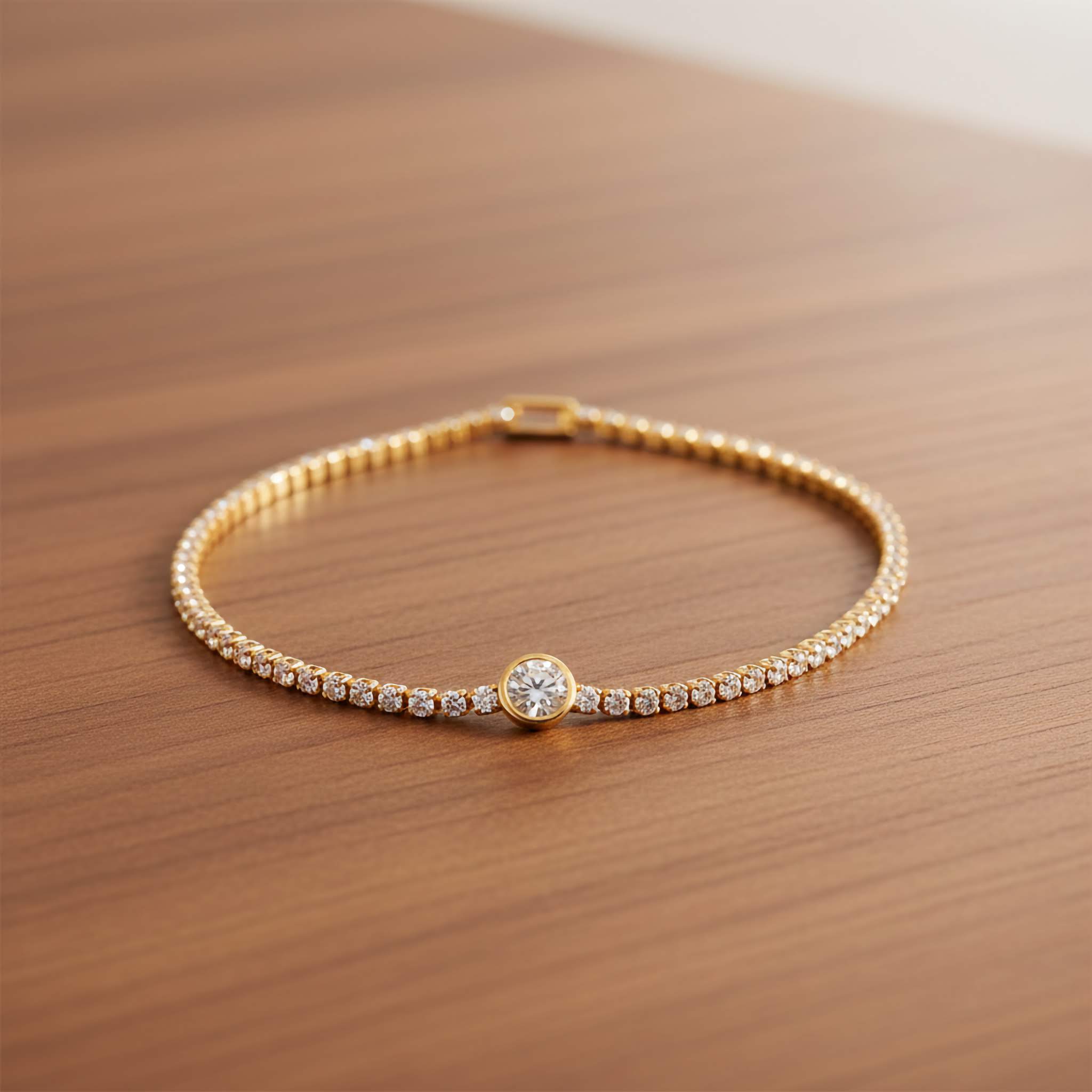 Gold platd tennis bracelet white crystals with a central diamond on a wooden surface